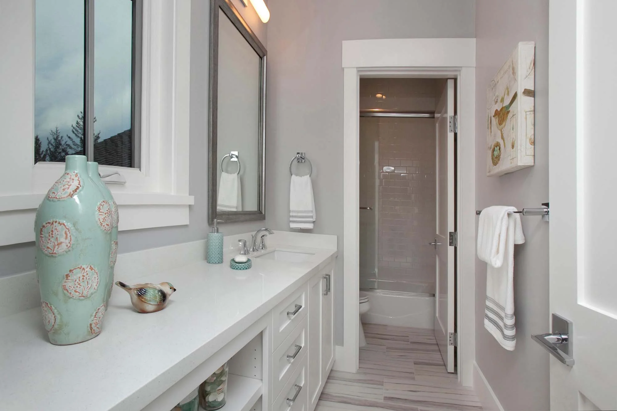 Bathroom with white furnishing, vase and mirror