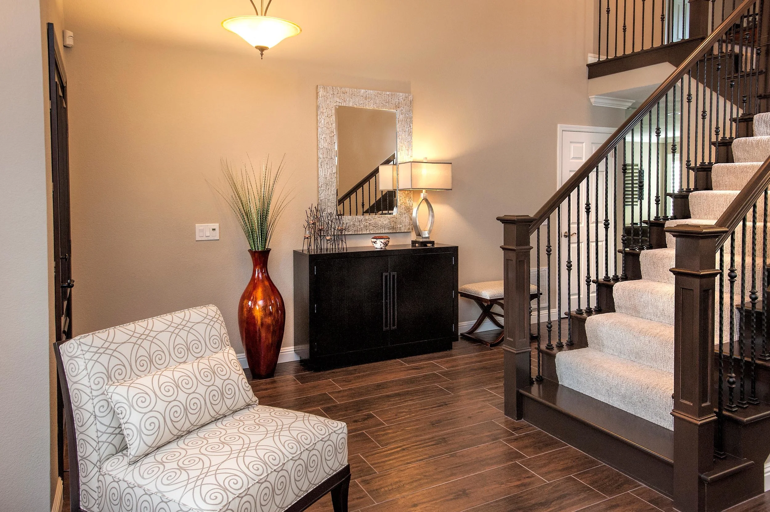 Stylish mirror, lamp, flower vase, cabinet and stairway with a sofa