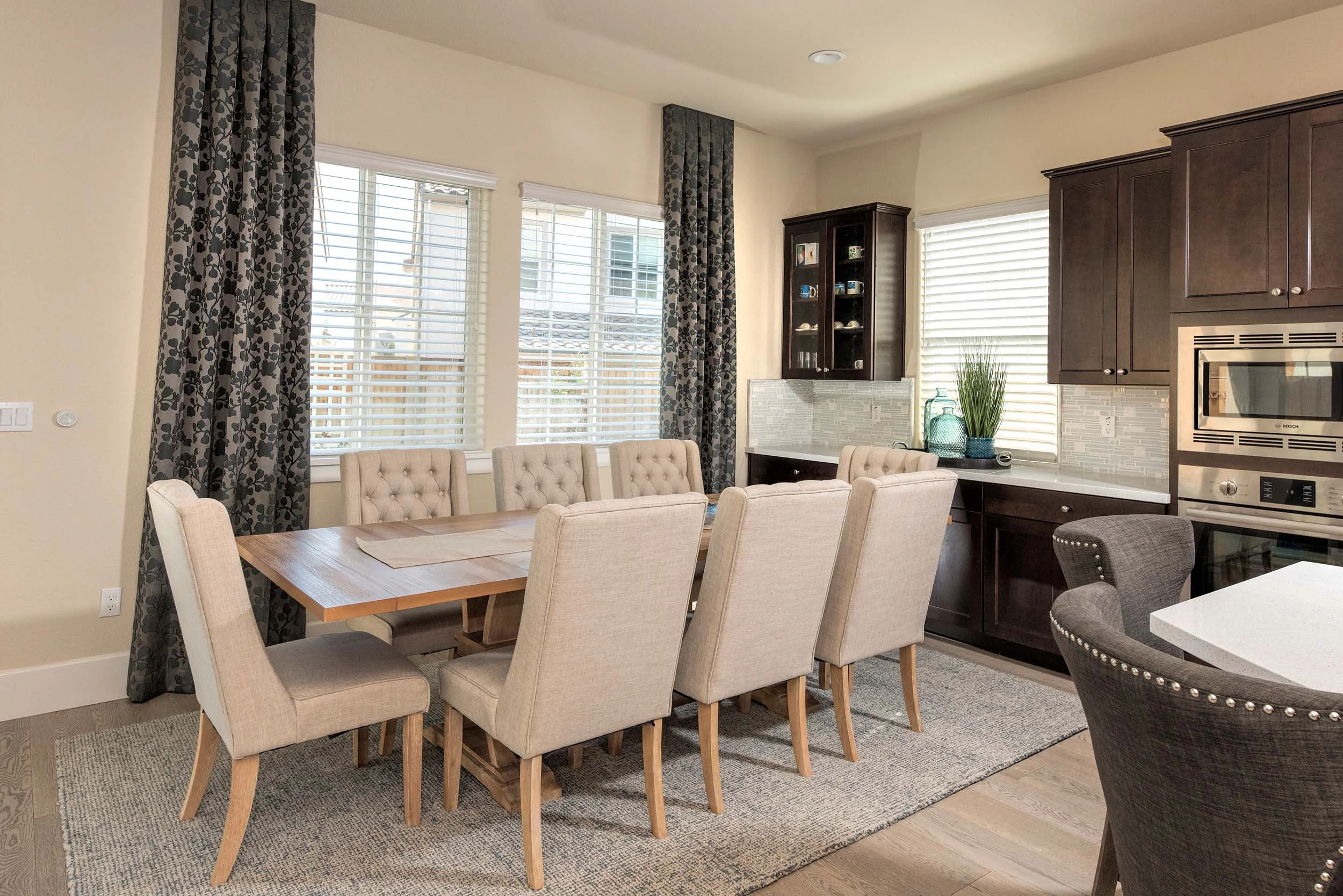 Dining room with chairs, wooden table, hardwood floor, and wooden cabinets