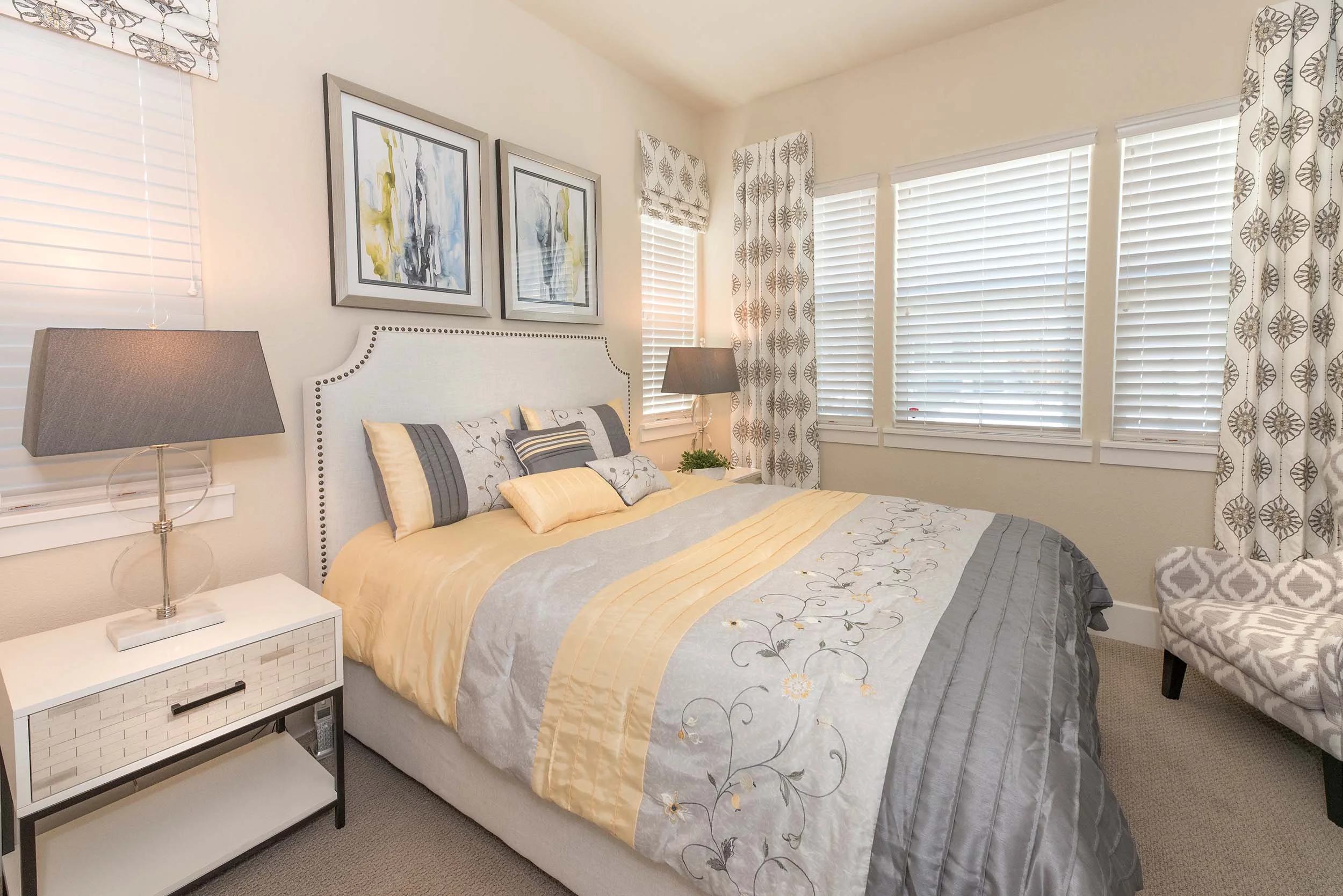 Bedroom with bedside table, table lamps and frames on the wall