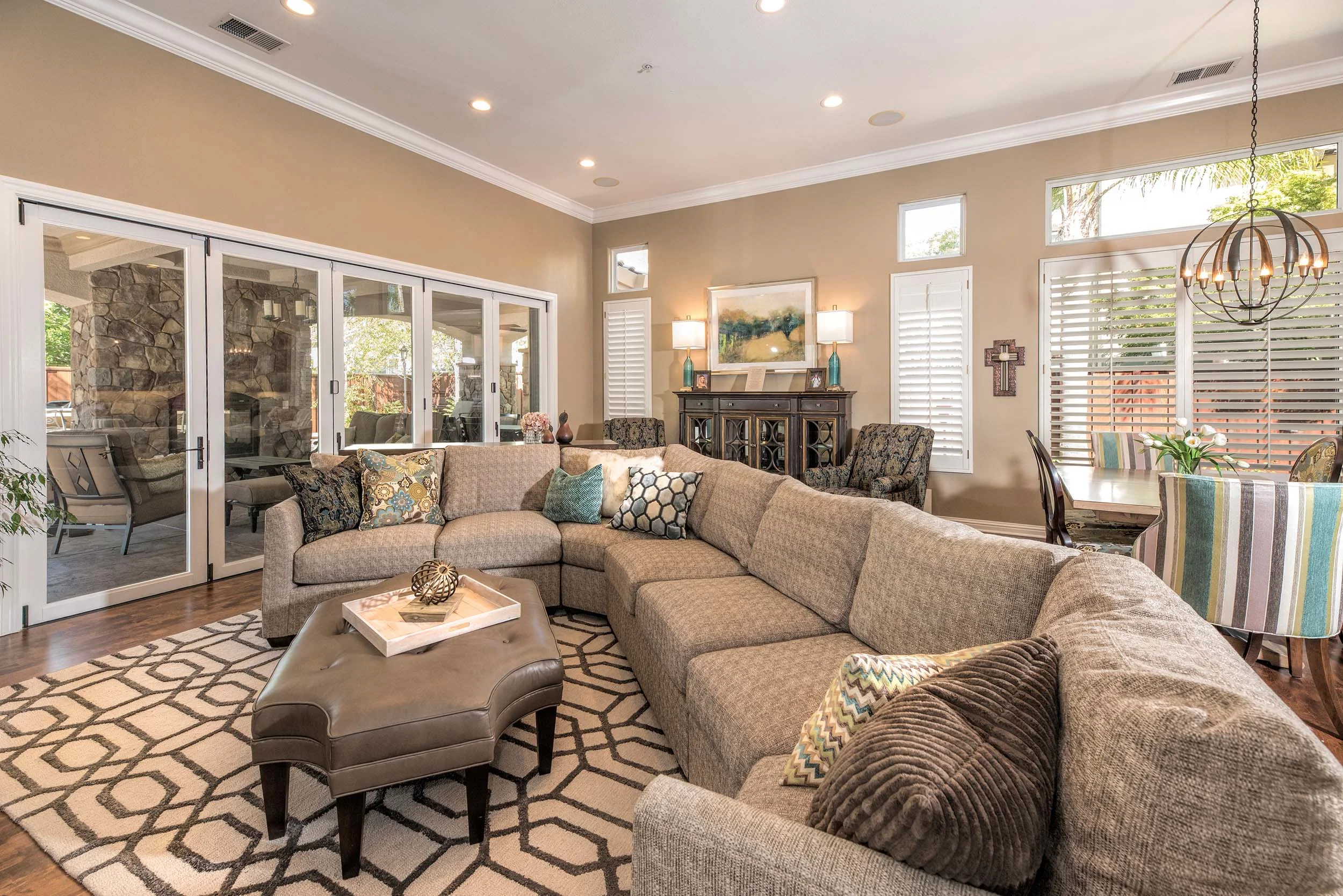 Living room with large sofa, set of pillows and white glass door