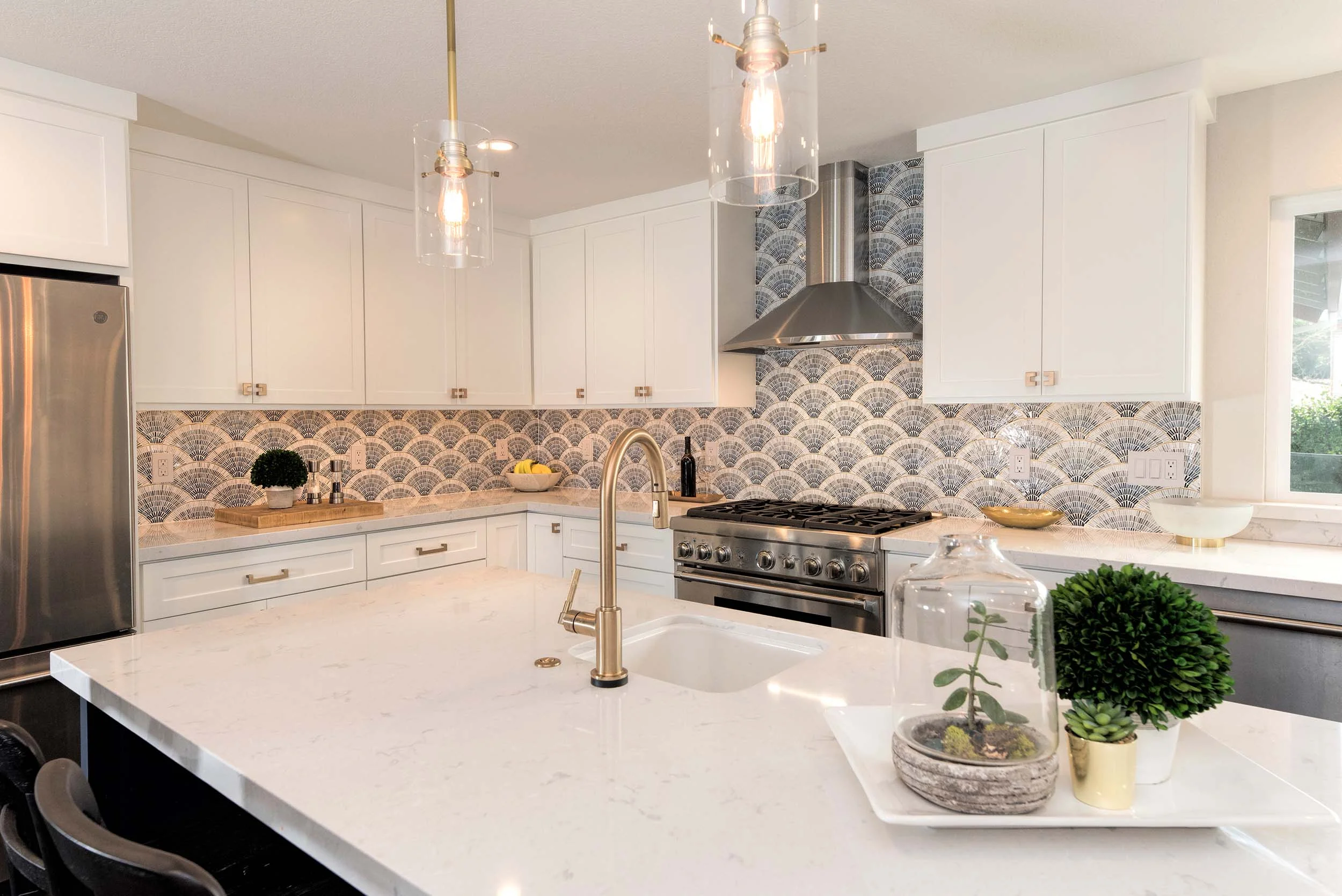 Kitchen with center island, faucet, granite countertop, exhaust hood and white wooden cabinet