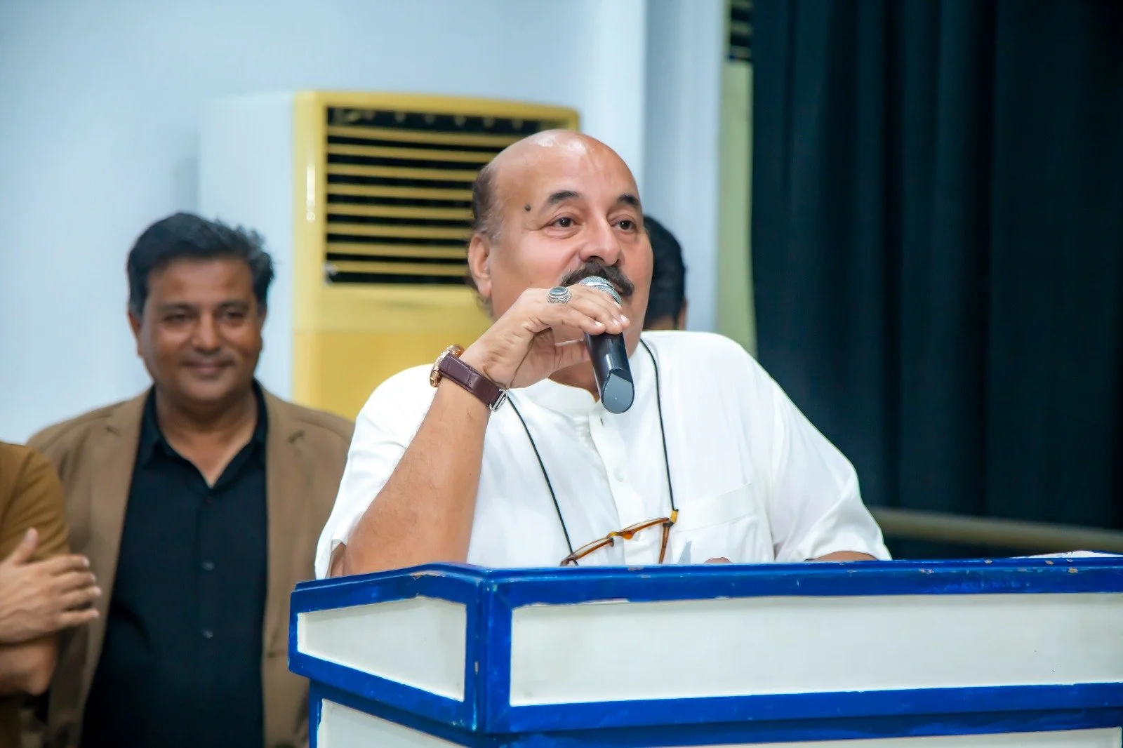 Rahmatullah Khan standing at a podium