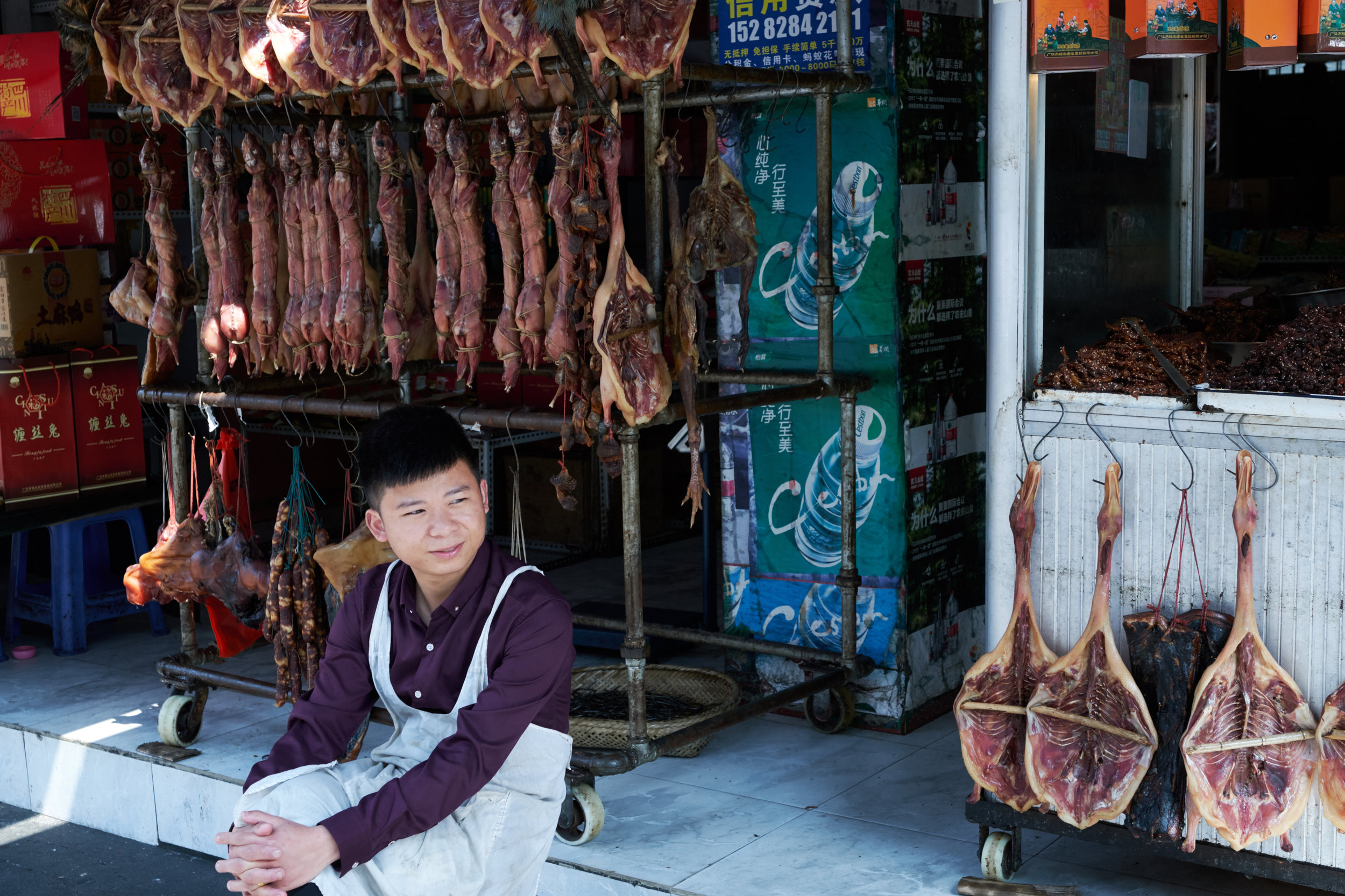 Vendor in Guanghan with red rabbit and other cured meats