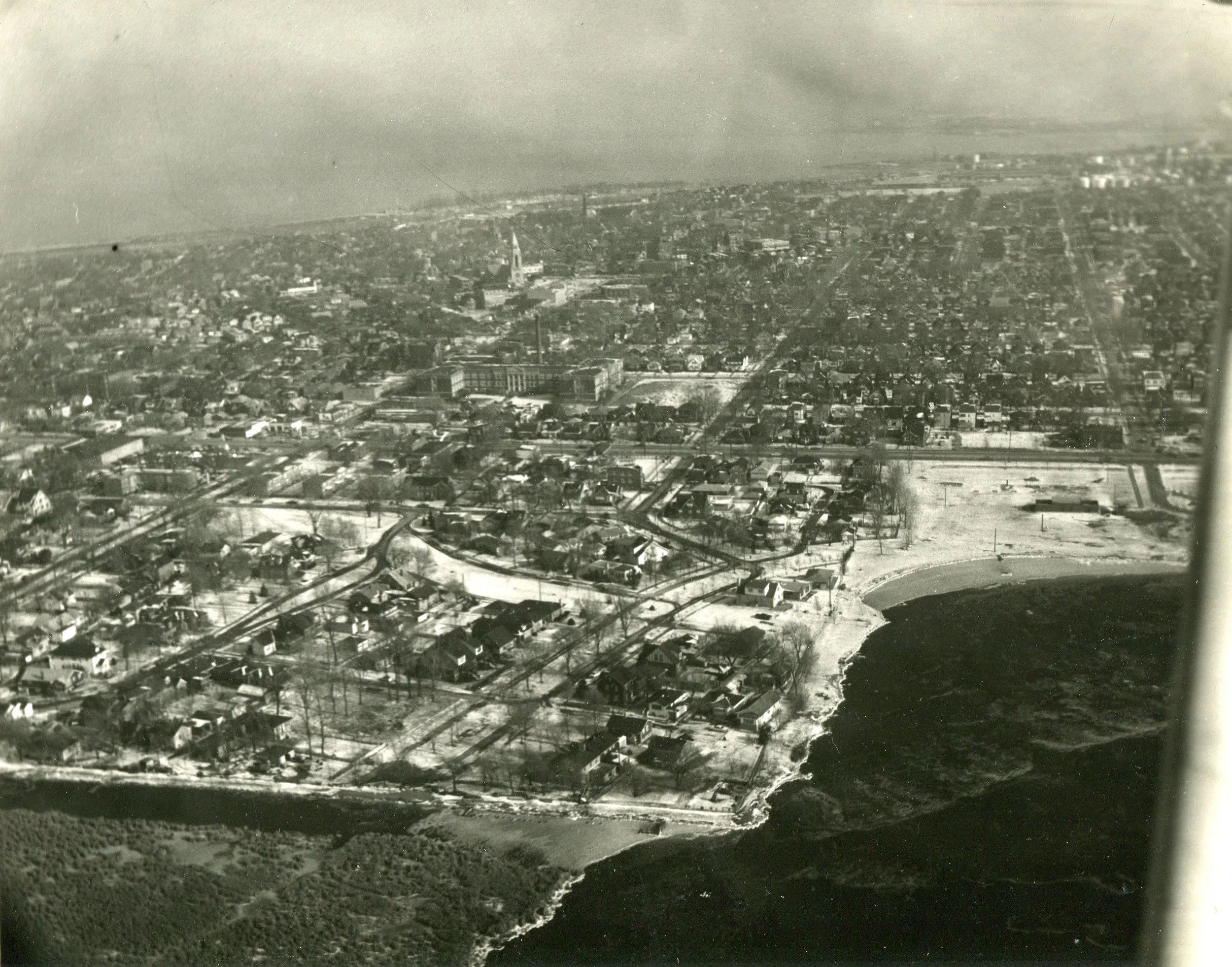 This aerial shot shows Wolf Lake in the bottom right part of the photo. and the Water Gardens to its left. The white swath just below the center of the photo is where Moylan’s Lagoon was located, and the smaller white patch at the left end of it is Forsythe Square. This photo was probably taken in the early 1960s.