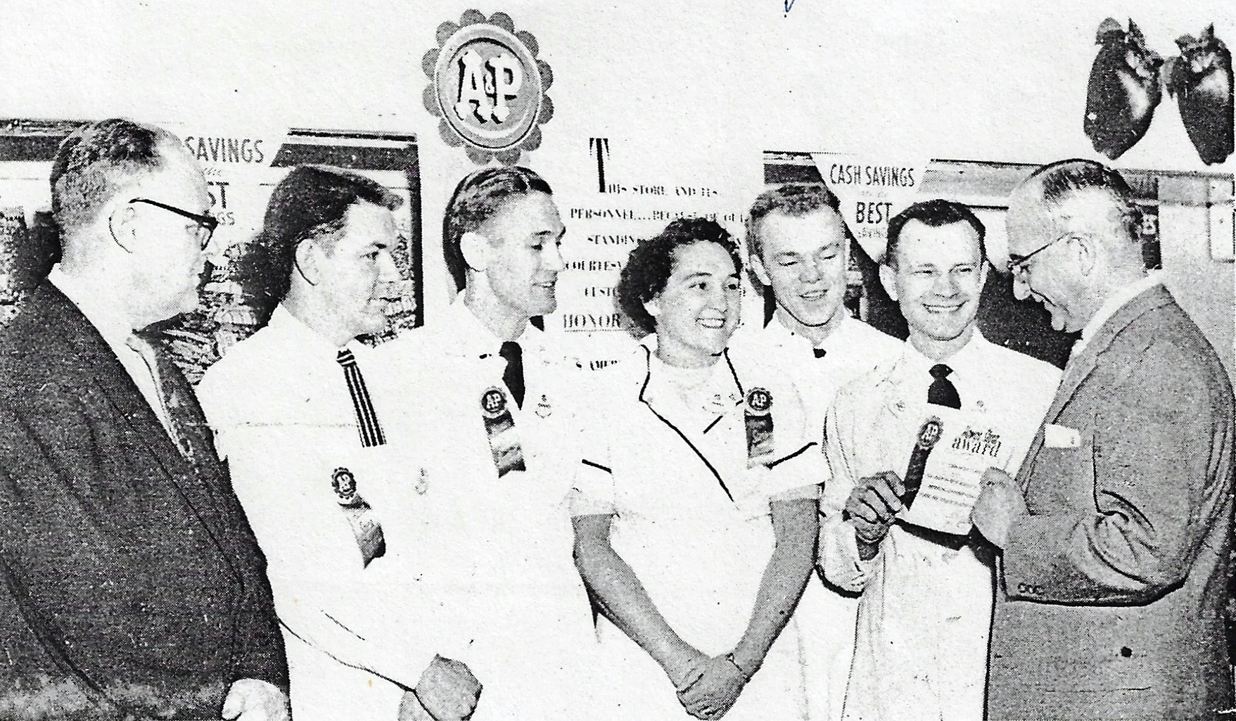 A&P Whiting employees accept an award for all employees for outstanding courtesy and customer service in 1958. From left to right are F. Kettles, district superintendent; Donald Utterback, assistant store manager; Clarence Goranowski, head of meat department; Mary White, cashier; Steve Krajnik, produce department; Mike Yaros, store manager; and K. Stitzer, Southside general superintendent of the A&P Company, Chicago.