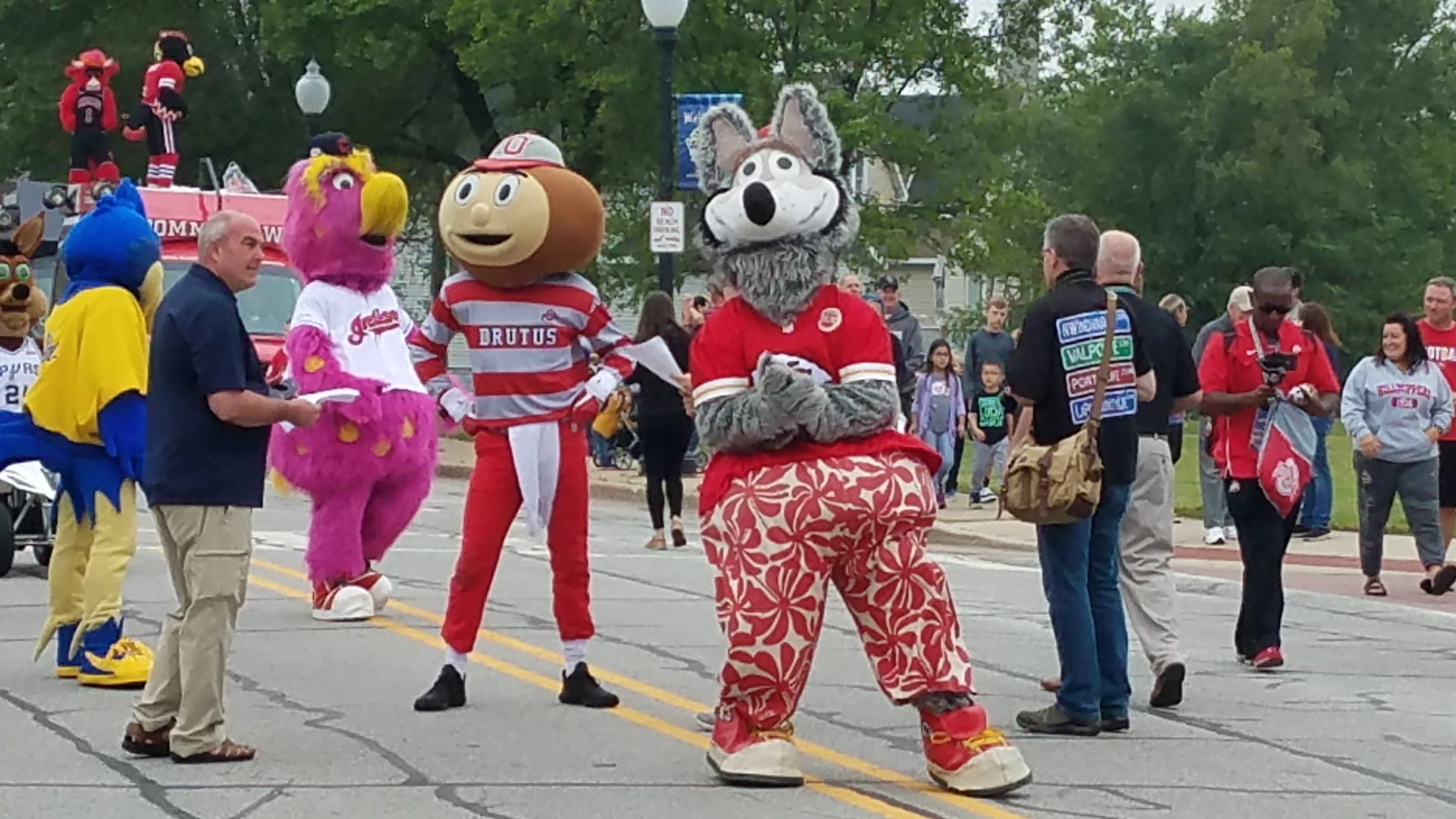 KC Wolf of the Kansas City Chiefs, Brutus Buckeye from Ohio State University, and Slider of the Cleveland Indians walk down 119th Street as part of the Hall-of-Fame induction weekend fun at the Mascot Museum in Whiting.