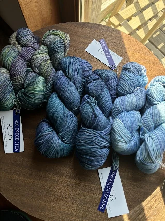 various colors of blue yarns on table