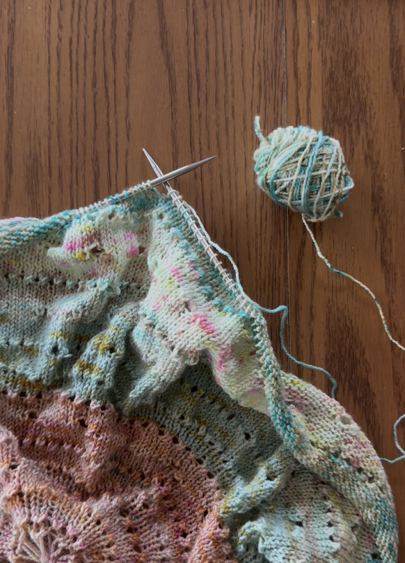 Colorful knitting project with yarn on wooden background