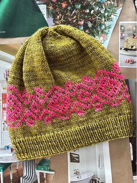pink and green knit hat with christmas background
