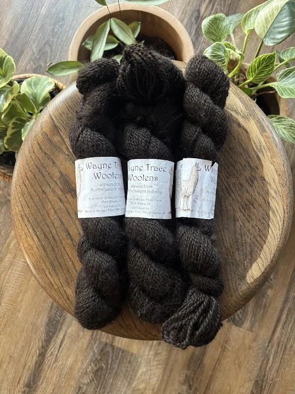 brown yarn surrounded by green plants