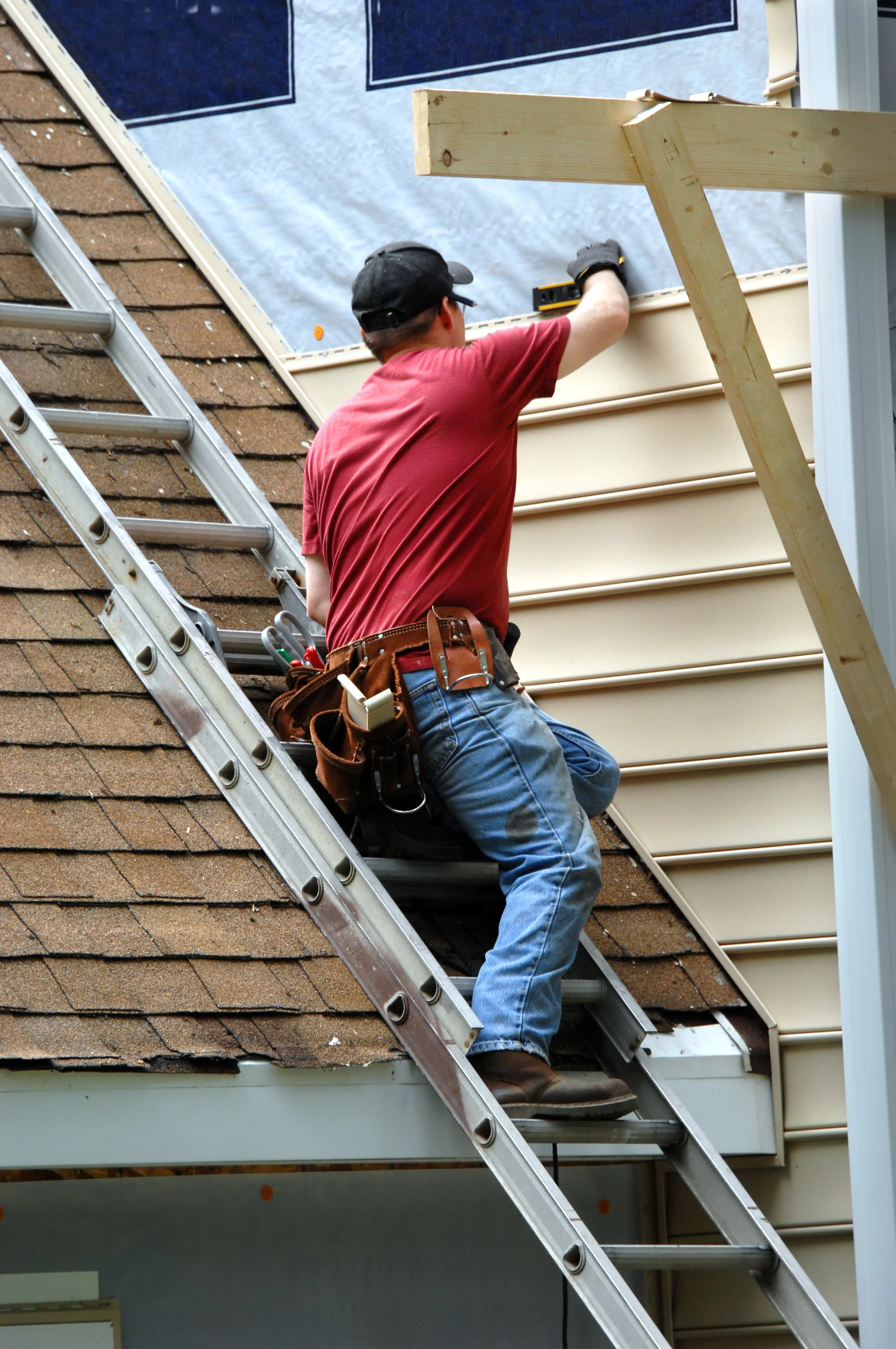 AdobeStock_52120700 man on ladder measuring siding.jpeg