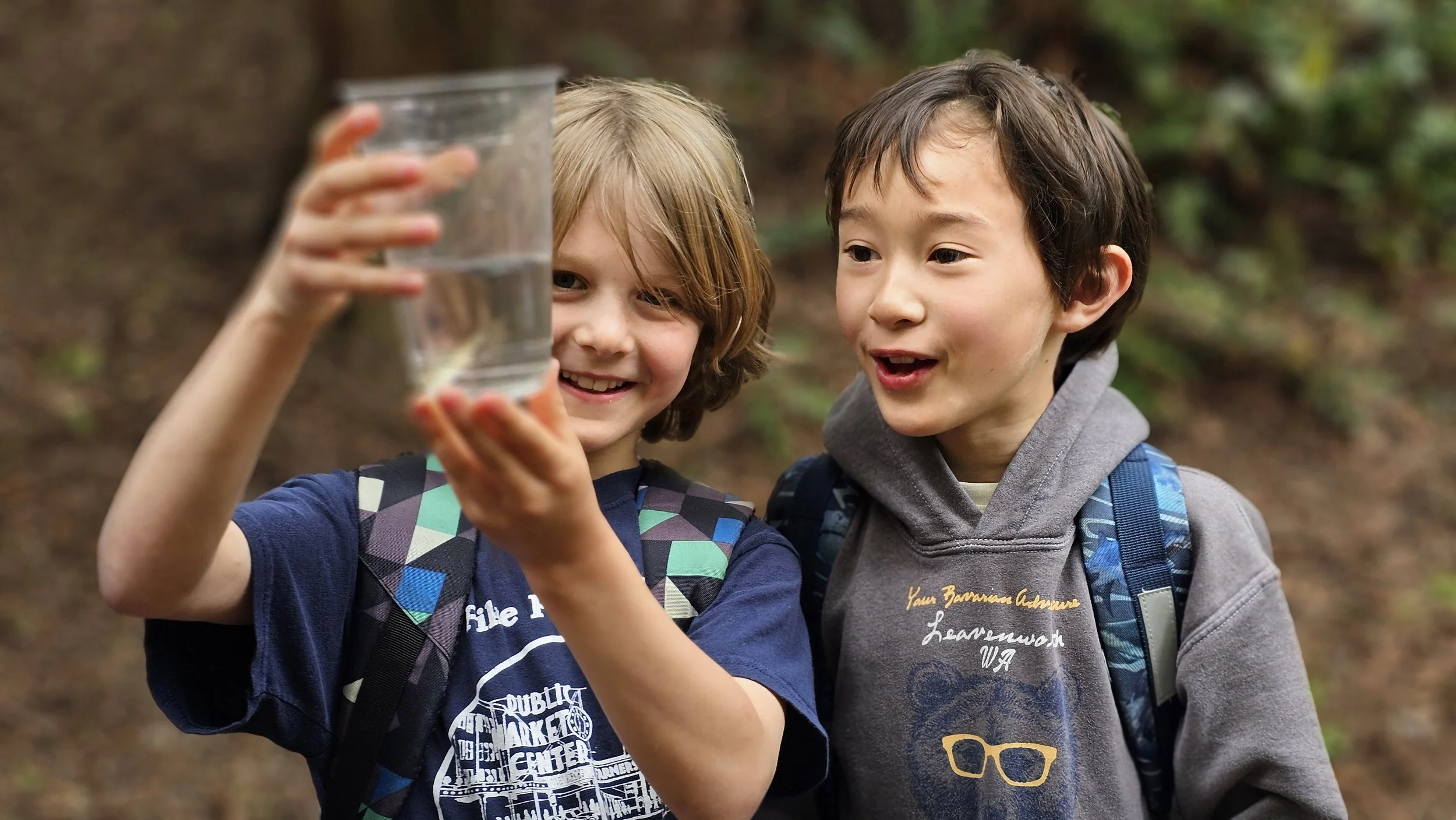 North Olympic Salmon Coalition - 2 kids looking holding glass with small salmon inside.jpg