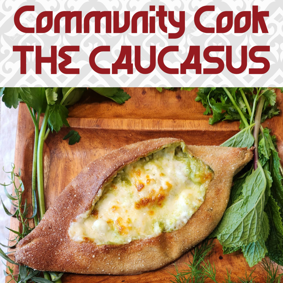 A cheesy casserole dish in the shape of a canoe, baked with a golden bubbly top, garnished with fresh green herbs, on a wooden serving board decorated with herbs.
