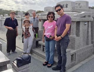 Janice Suetomi and her children pay respects to her ancestor at the dhaka in Okinawa.