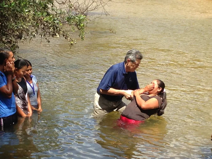MAG missionary Pastor Carlos Paz baptizing in the Rus Rus River.