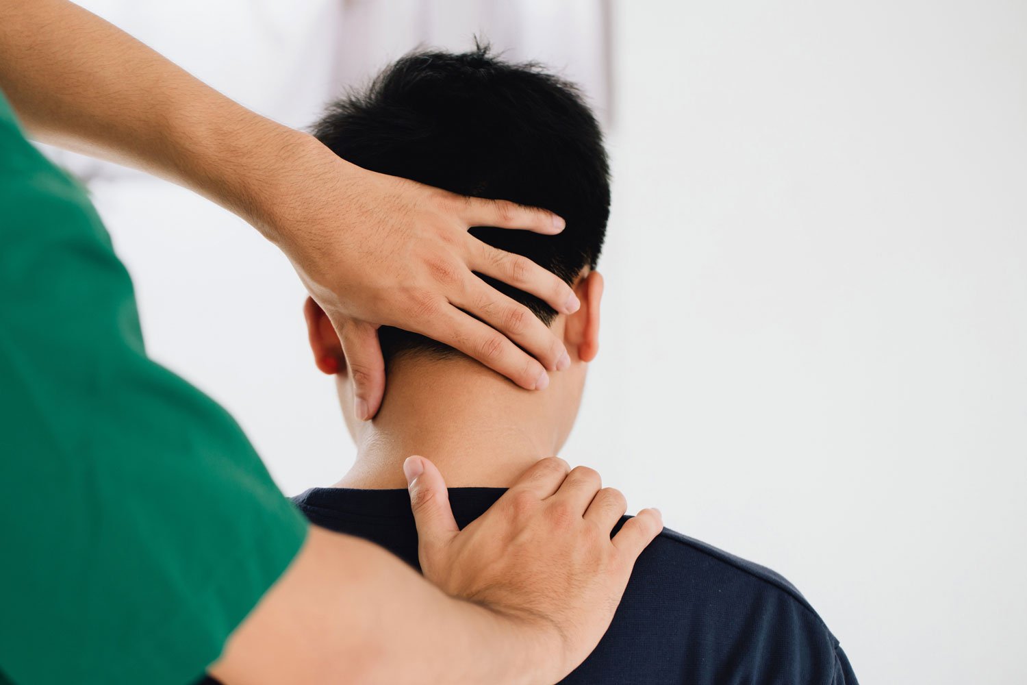 Patient receiving a neck and back physical examination or chiropractic treatment from a chiropractor.