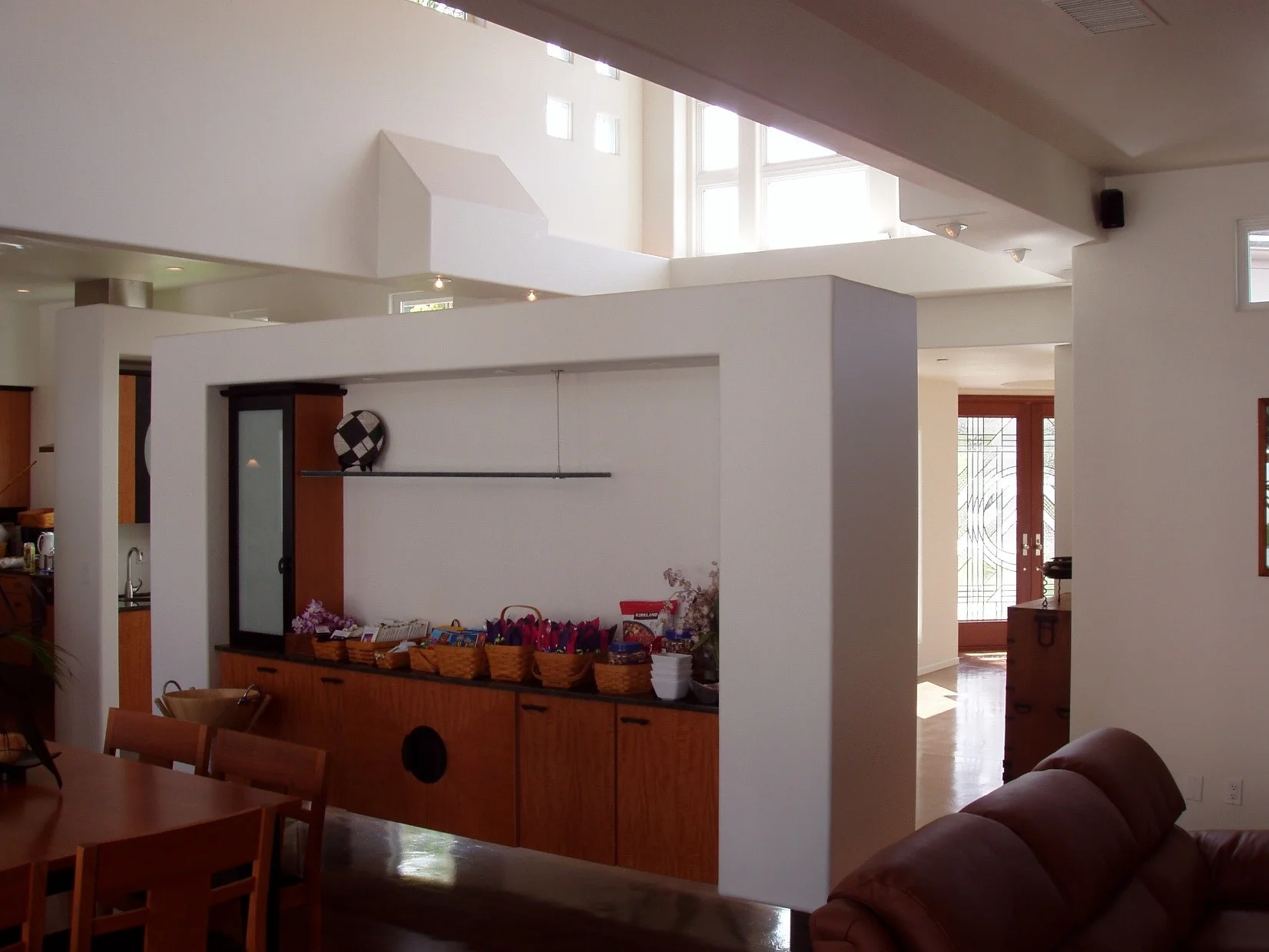 The Great Room side of the Floating Wall containing storage and a small buffet platform serving the dining room table.The Foyer and entry doors can be seen to the right, beyond. 