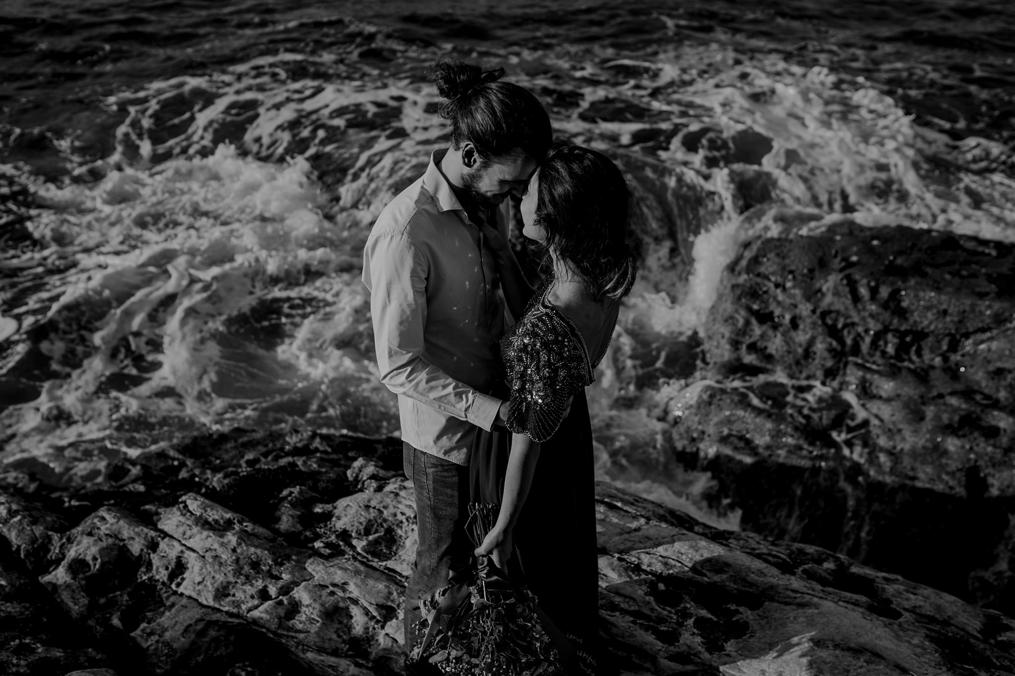  crashing waves around a couple during their engagement session on the North Coast 