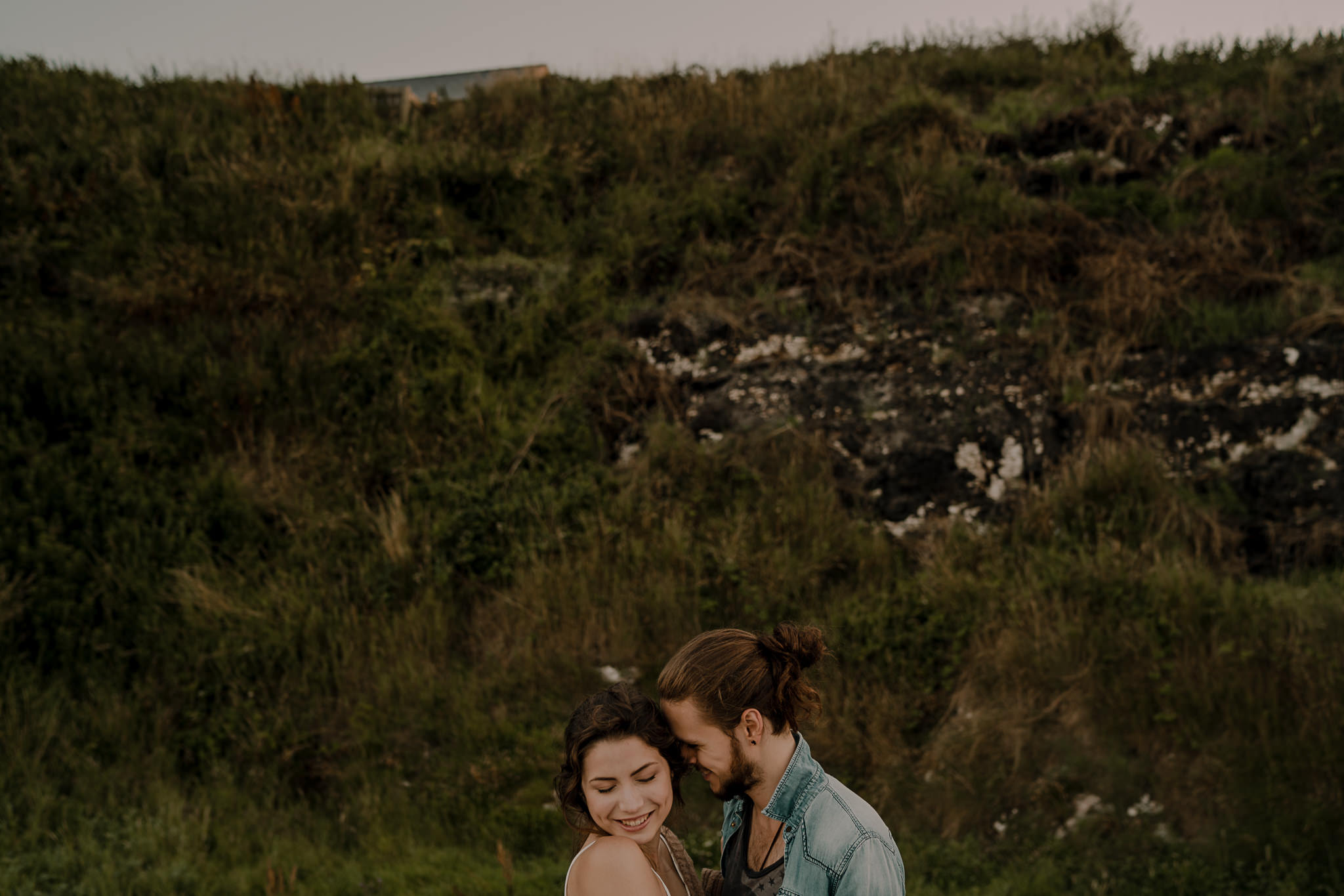  sweet guy whispers in her ear during engagement shoot on the causeway coastal route 