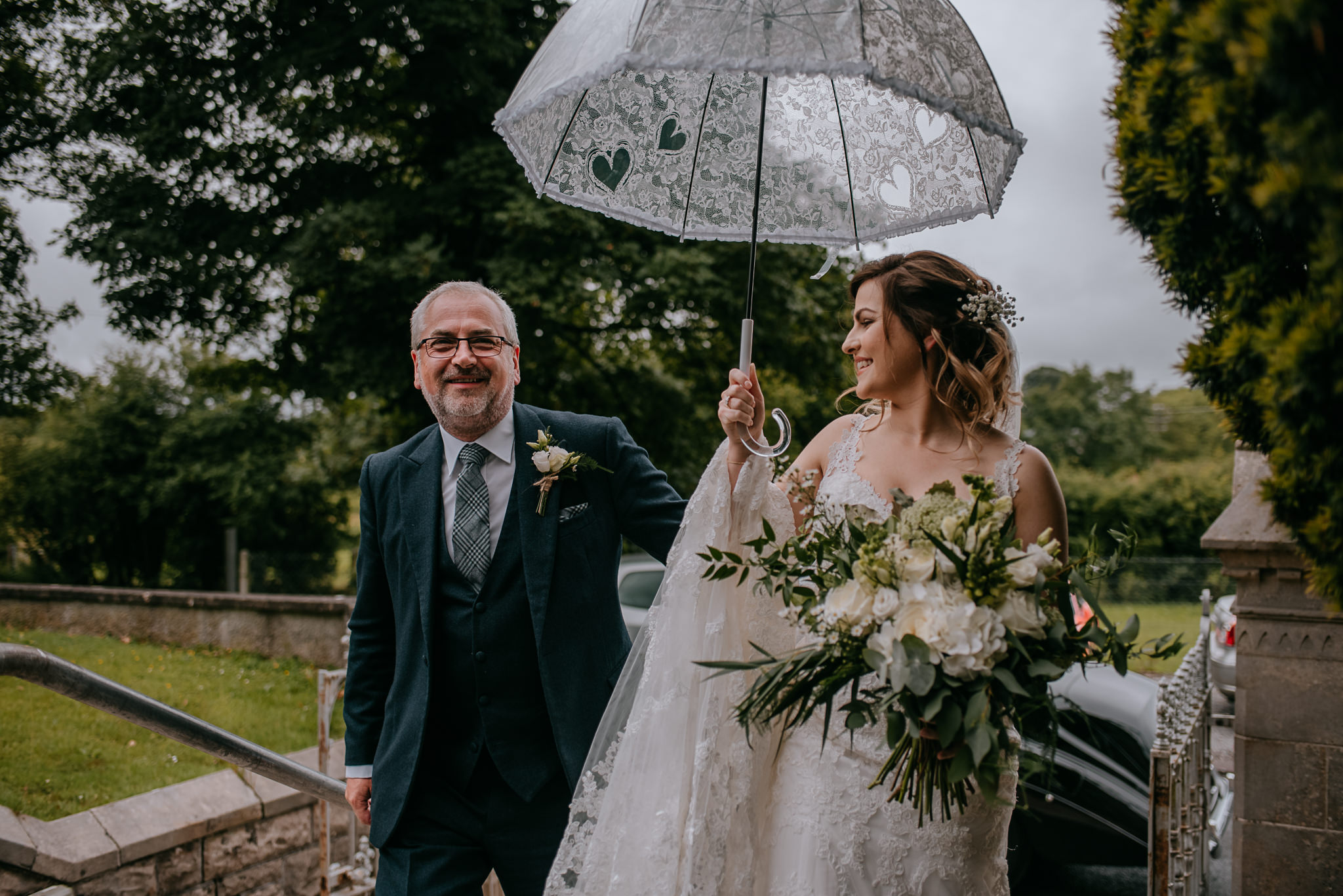  bride and father arrive at ceremony umbrella Northern Ireland Wedding Photographers 