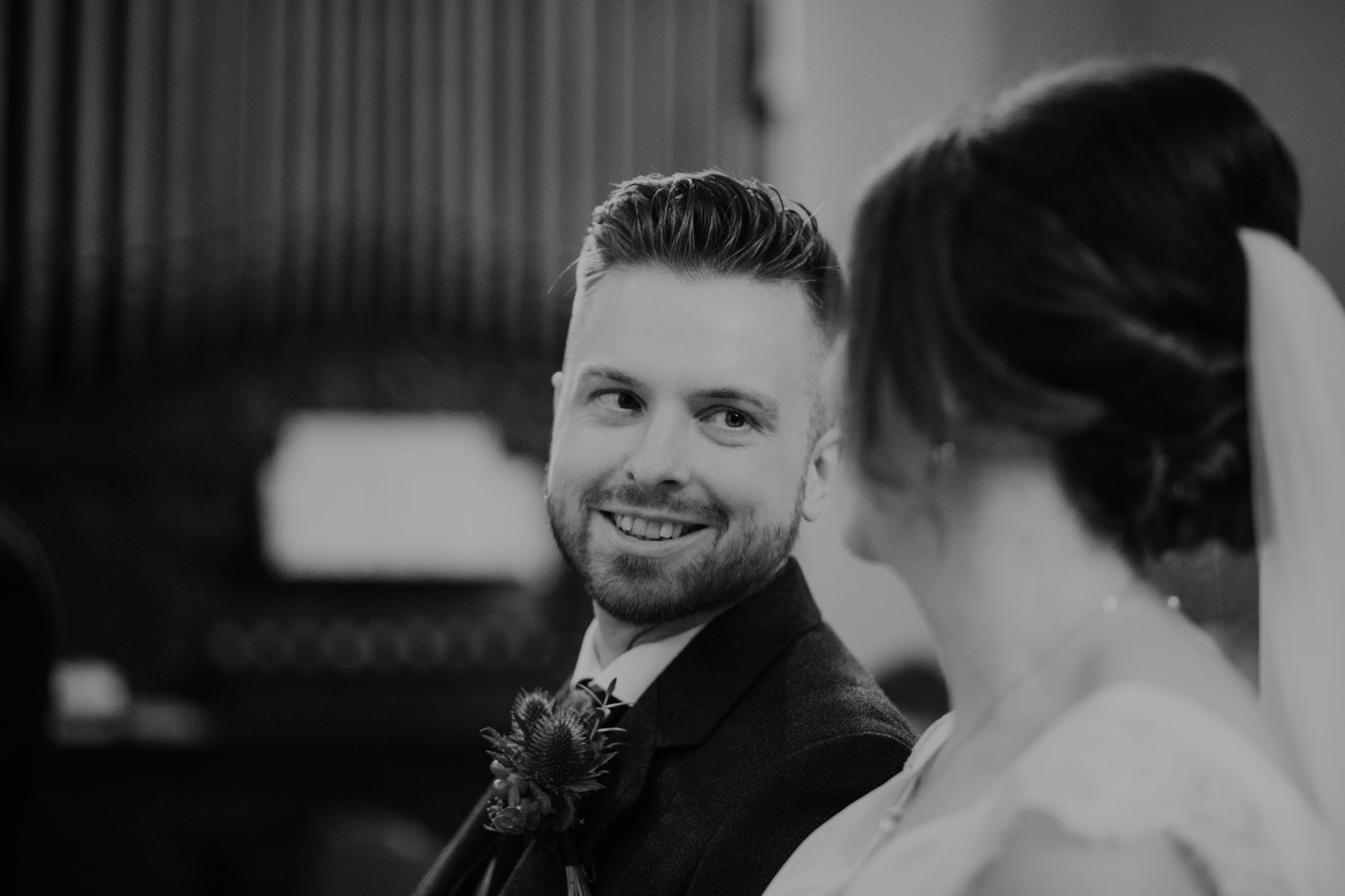 groom looks at bride ceremony