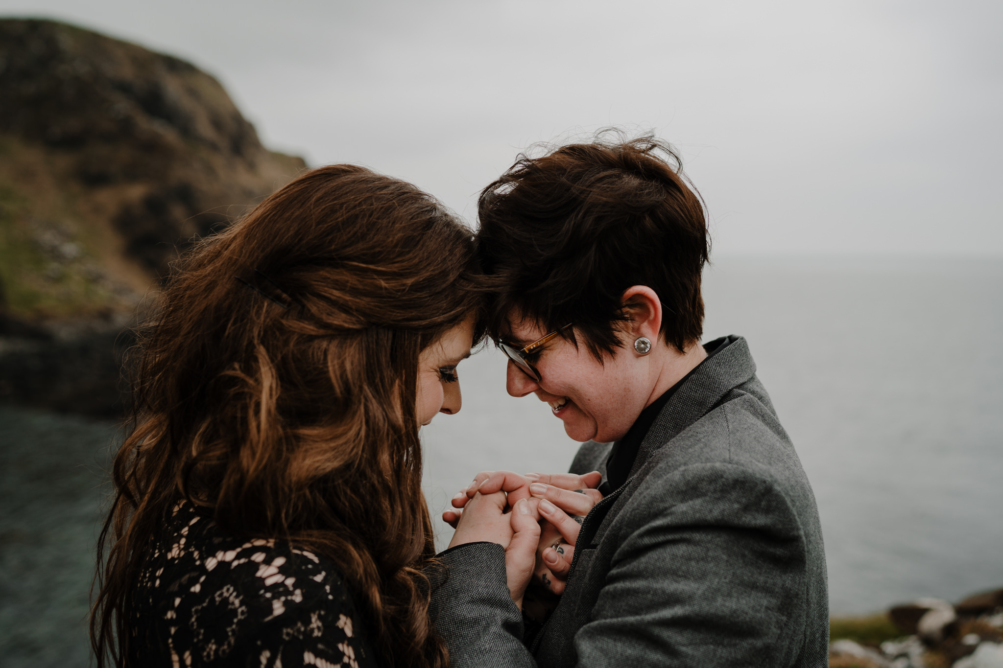 Two girls hold hands smile north coast Kinbane castle engagement session