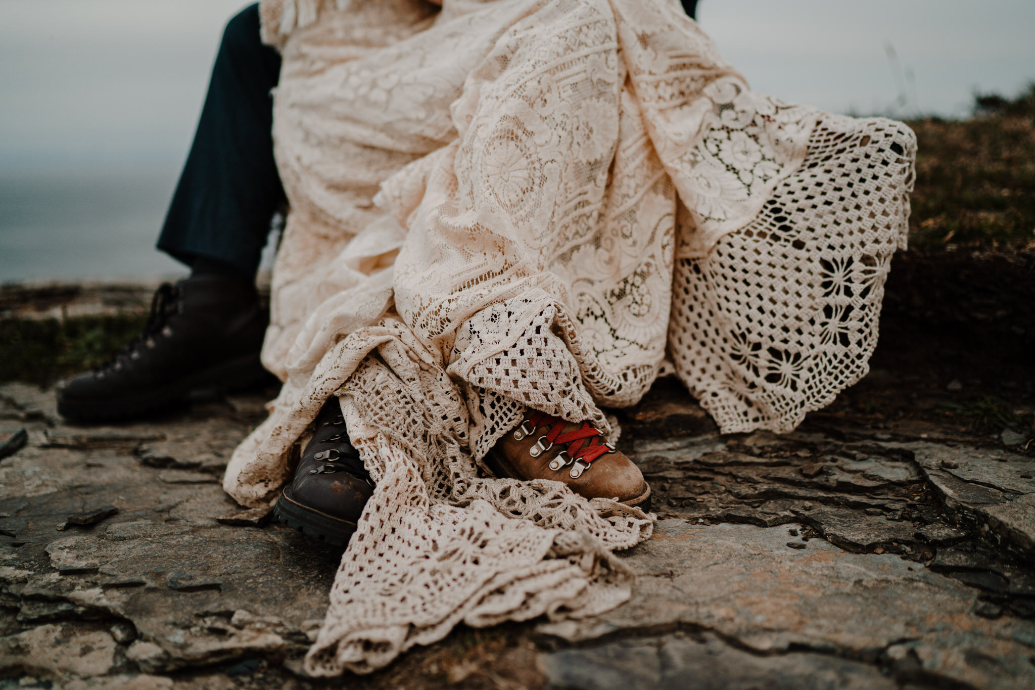 close up danner hiking boots and custom lace reclamation wedding dress Cliffs of Moher ireland