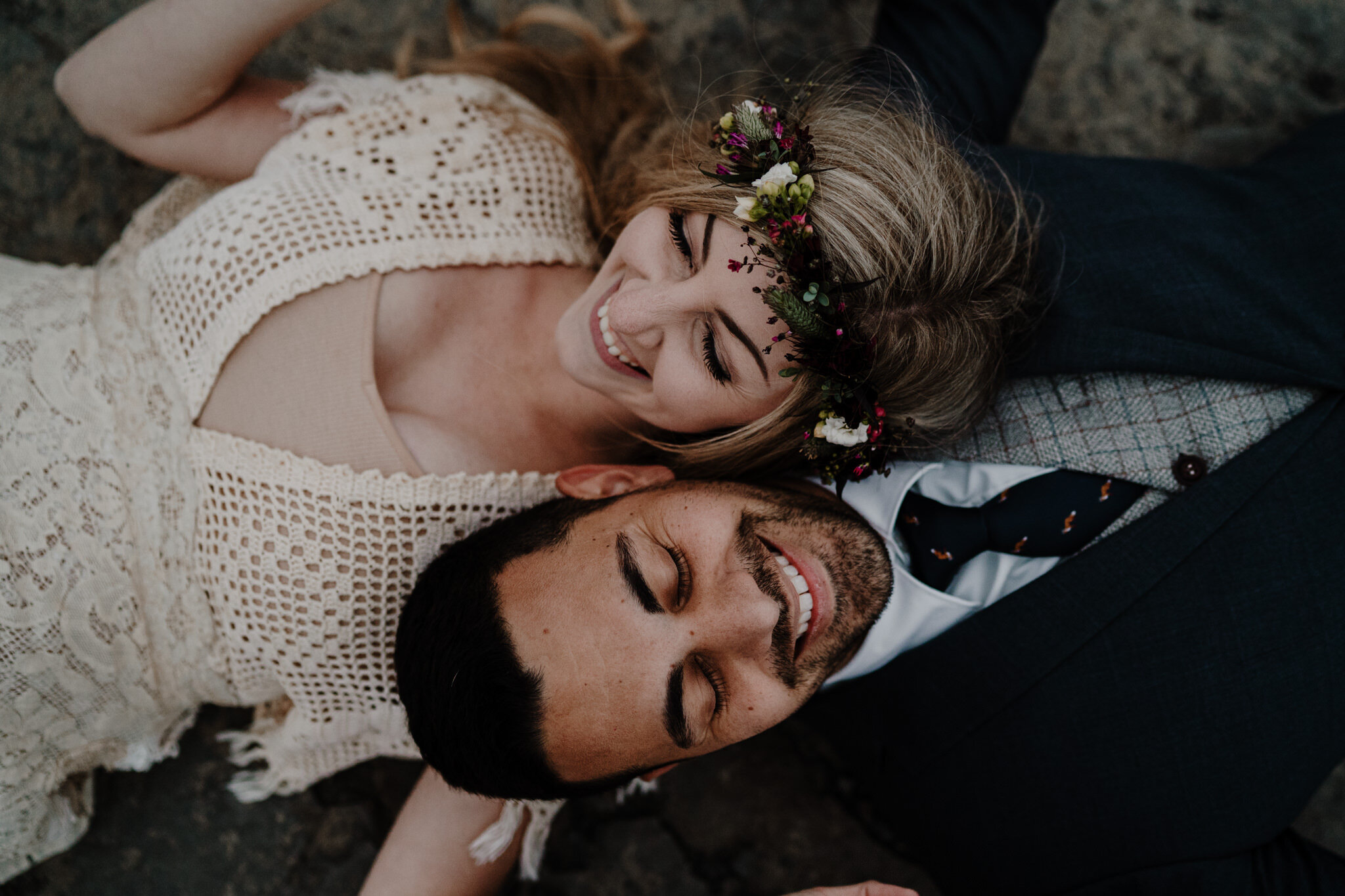 couple lay on cliff edge laughing Cliffs of Moher ireland