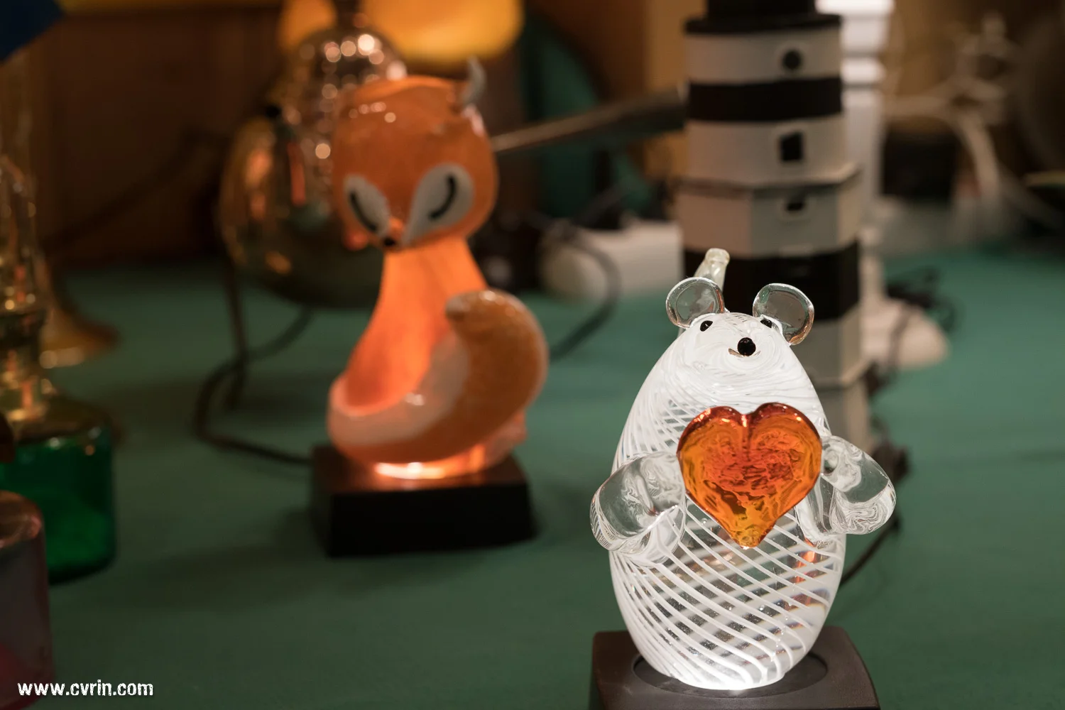 Une souris illuminée offrant son amour en vitrine, avec un joli renard en retrait.