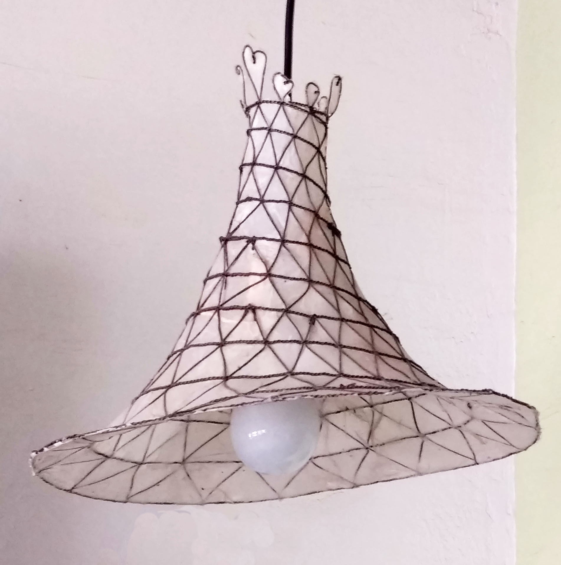 This flared pendant light has a creamy-colored natural rice paper under a woven steel wire net.