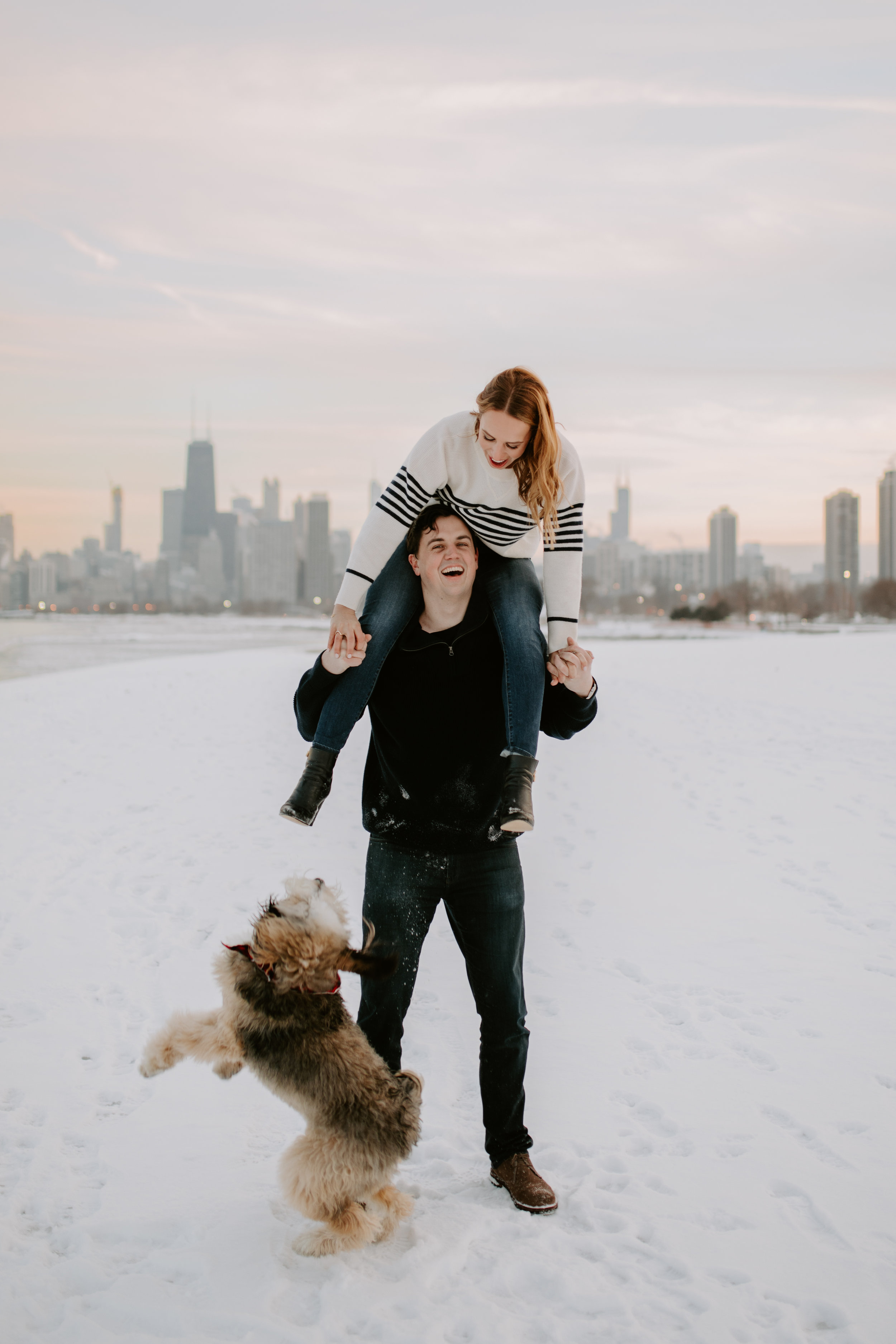 Puppy included in couple’s winter engagement photo session with Chicago sunset at Chicago Lakefront, captured by Kerri Carlquist Photography. Find more inspiration at chitheewed.com!