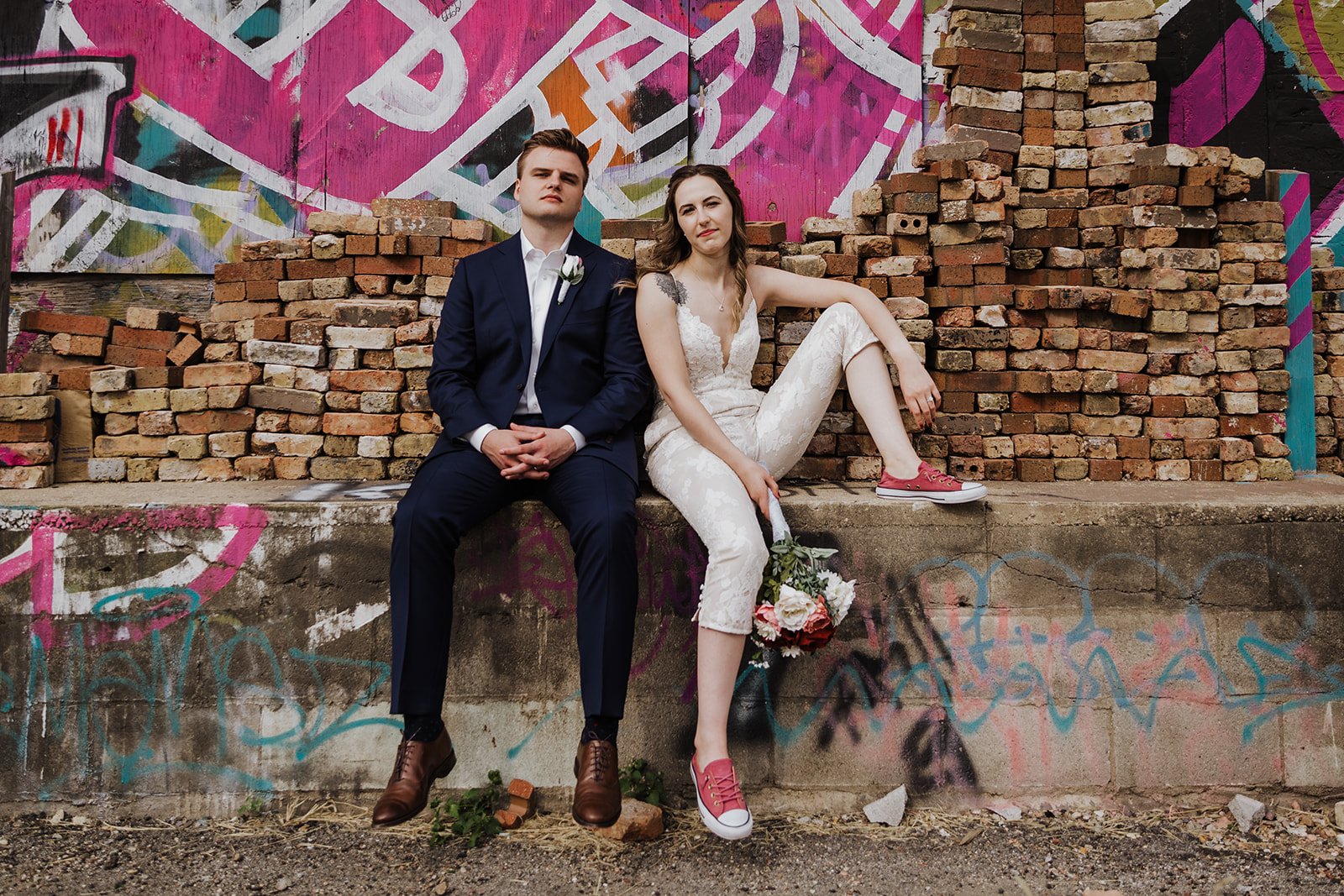 Chicago elopement couple sitting on legde in front of pink street art mural editorial photo.jpg