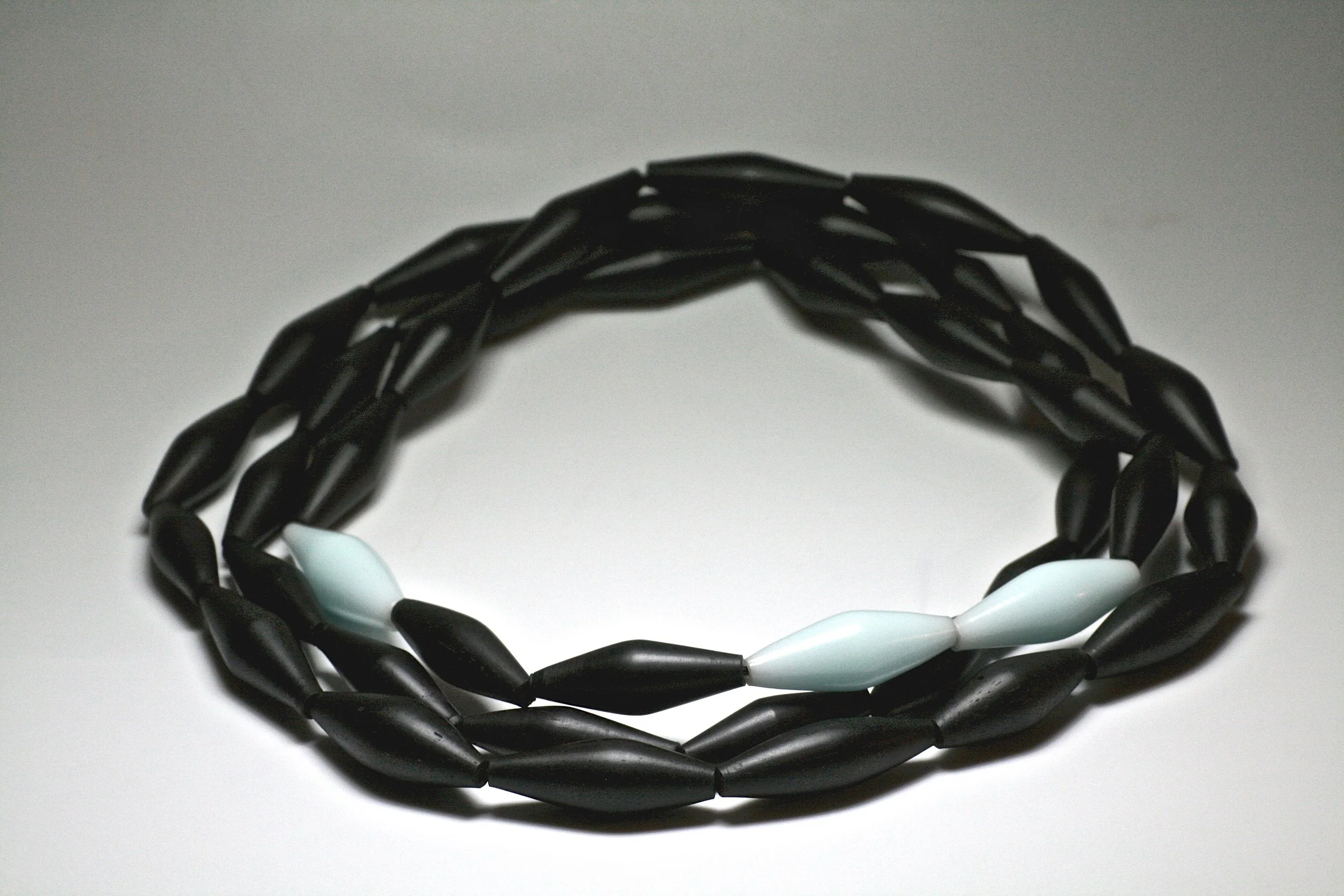 A client came to me with a box of old ebony piano keys. This long necklace was created.