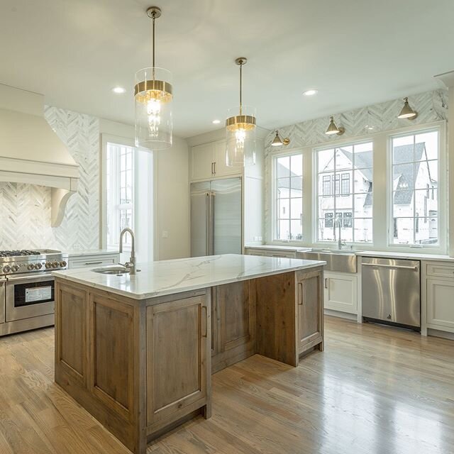 A recently completed custom home showcases this large, open kitchen with tons of natural light flooding the space. #watershollandbuilders #watersholland #customhome #newconstruction #appliances #marble #customcabinets #kitchensofinstagram