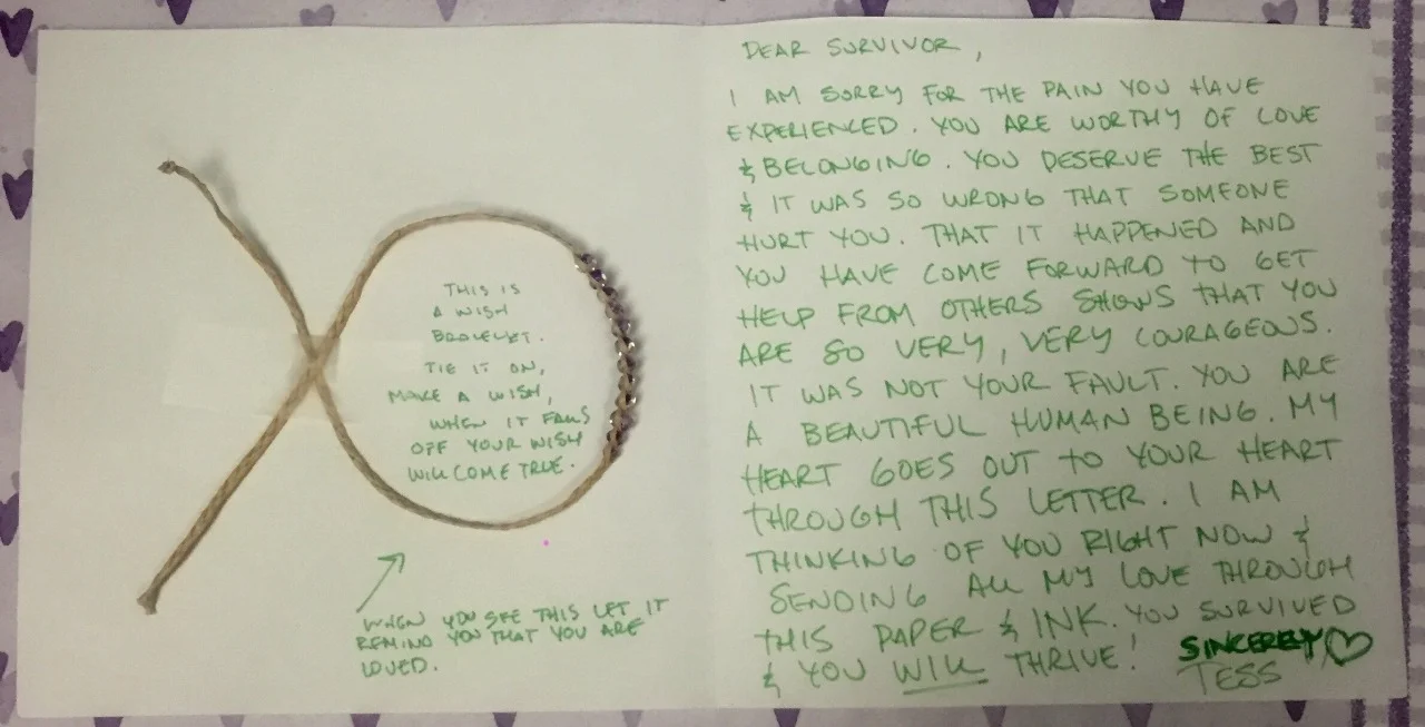 Dear Survivor, I am sorry for the pain you have experienced. You are worthy of love & belonging. You deserve the best & it was so wrong that someone hurt you. That it happened and you have come forward to get help from others shows that you are so very, very courageous. It was not your fault. You are a beautiful human being. My heart goes out to your heart through this letter. I am thinking of you right now & sending all my love through this paper & ink. You survived & you will thrive! Sincerely, Tess (Inside the circle of a bracelet taped to the letter):This is a wish bracelet. Tie it on, make a wish. When it falls off your wish will come true. (Next to arrow pointing to the bracelet)When you see this let is remind you that you are loved.