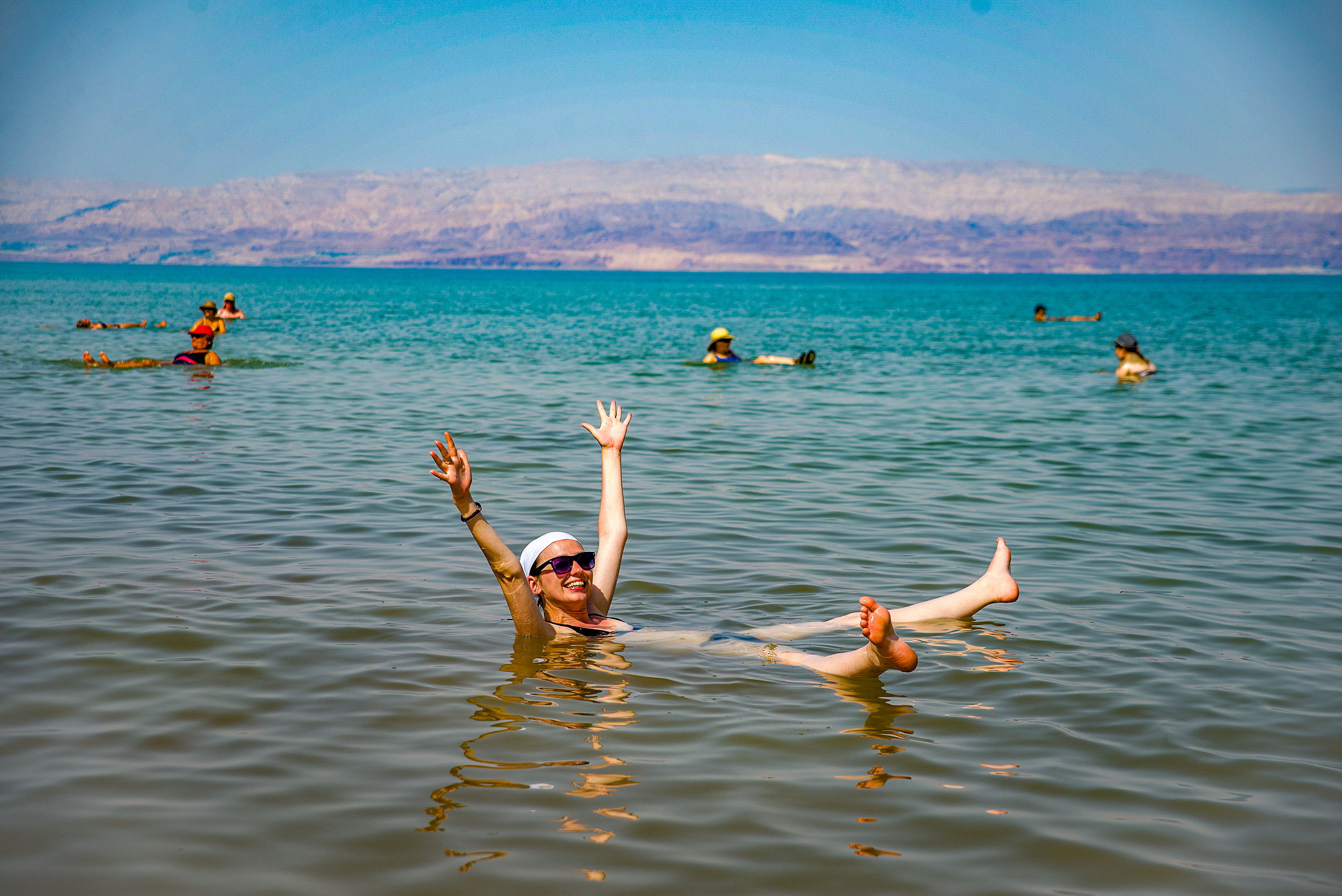 Мертвое море человек на воде. Мертвое море купание. Мертвое море купальни. Мёртвое море люди купаются.