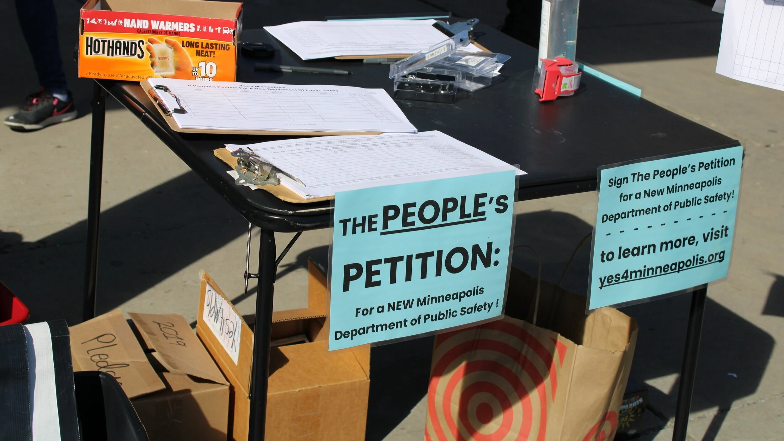 A table with signs and petitions for the Yes4Minneapolis campaign.