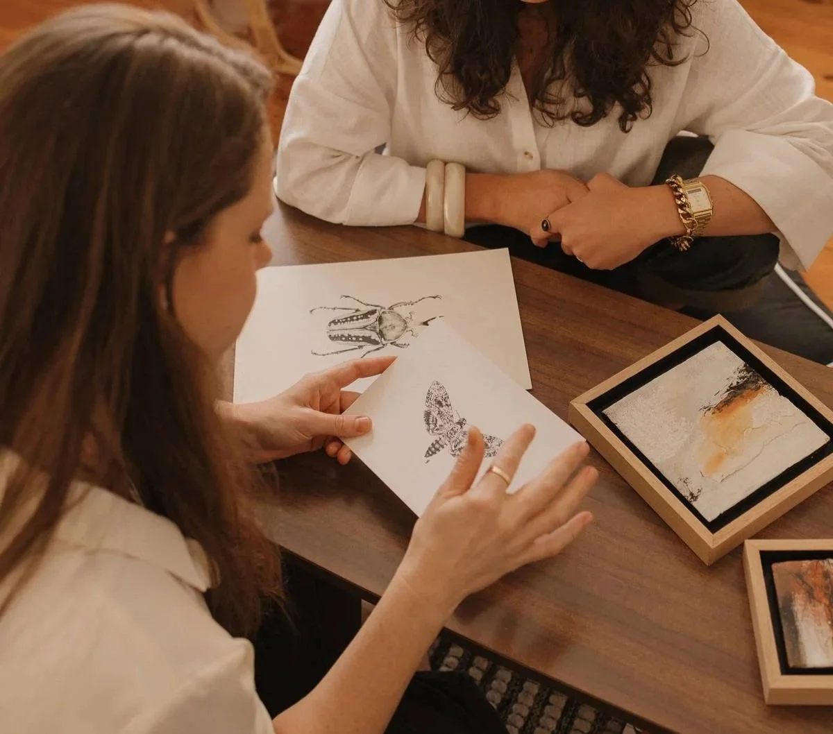 Alanya van de Wiel looking at Julie Brondino stippling artworks and abstract paintings