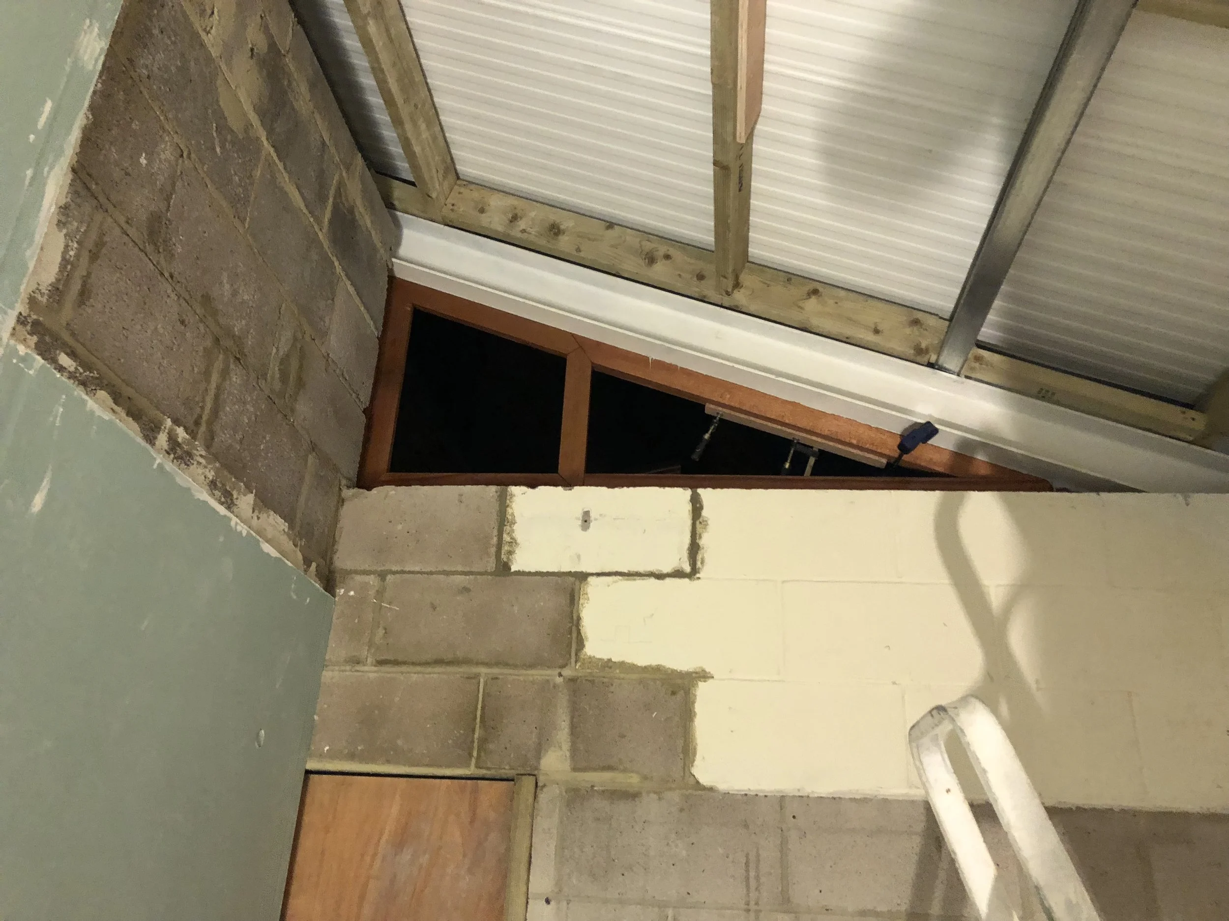 Fitting the high window frame to the new physio’s room, viewed from inside.