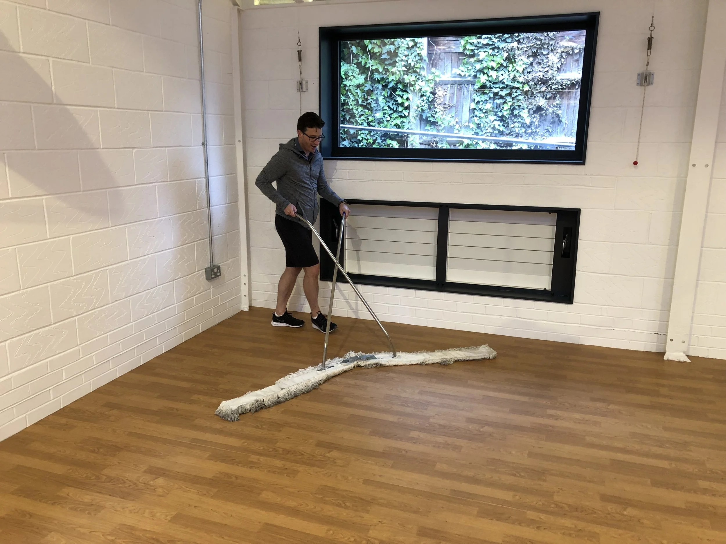 Jason Gray multi-tasking, enjoying polishing the new large gym floor