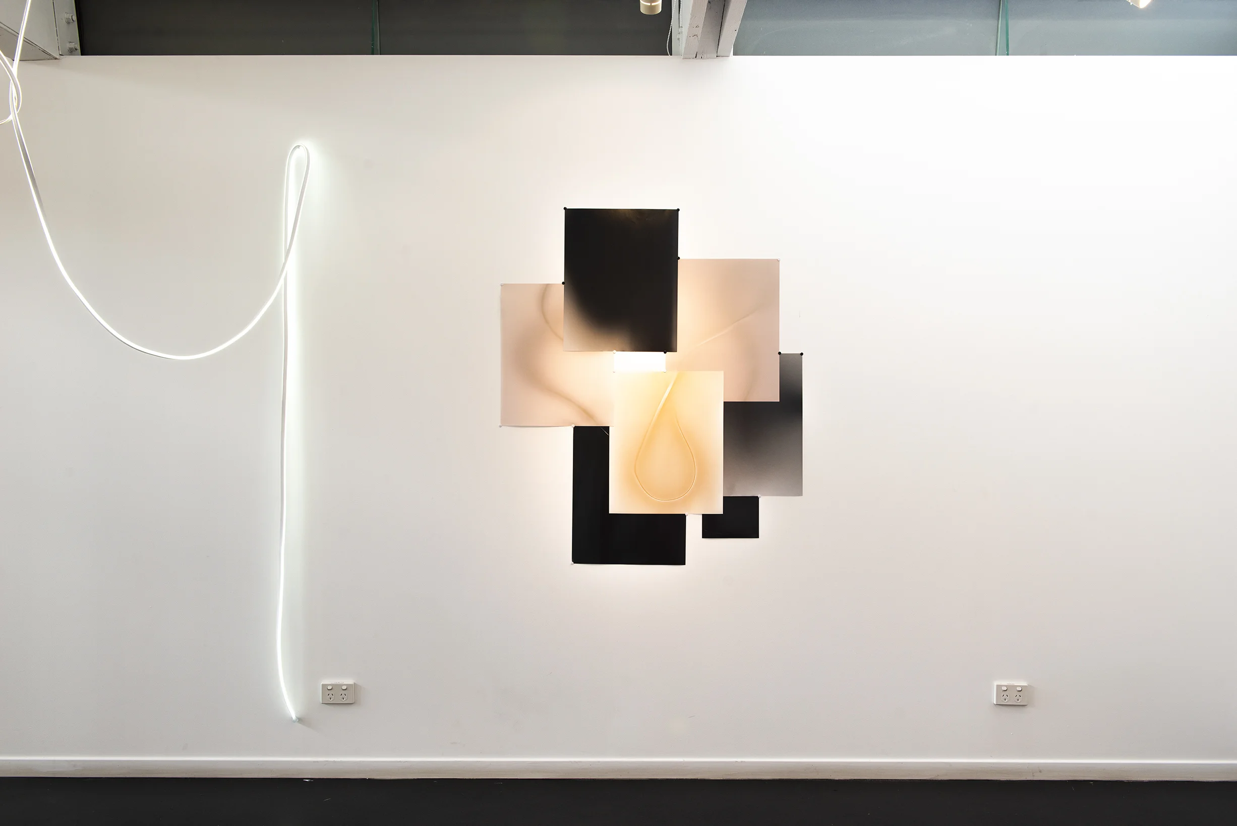 I nstallation view Peacock Gallery, Nov 2018. Afterglow and The Last Touch are interconnected works that explore relationships between light, dark, time and chance. The LED light sculpture was laid upon photographic paper to make the lumen prints and photograms that make up the photo collage. The two works create an installation that explores illumination in both a three-dimensional and two-dimensional rendering. Through variations in developing times, the touch of the light onto the photographic paper either reveals or conceals what has been laid upon it.