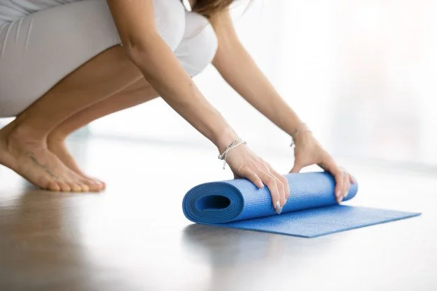 close-up-female-hands-unrolling-yoga-matress_1163-5427.jpg