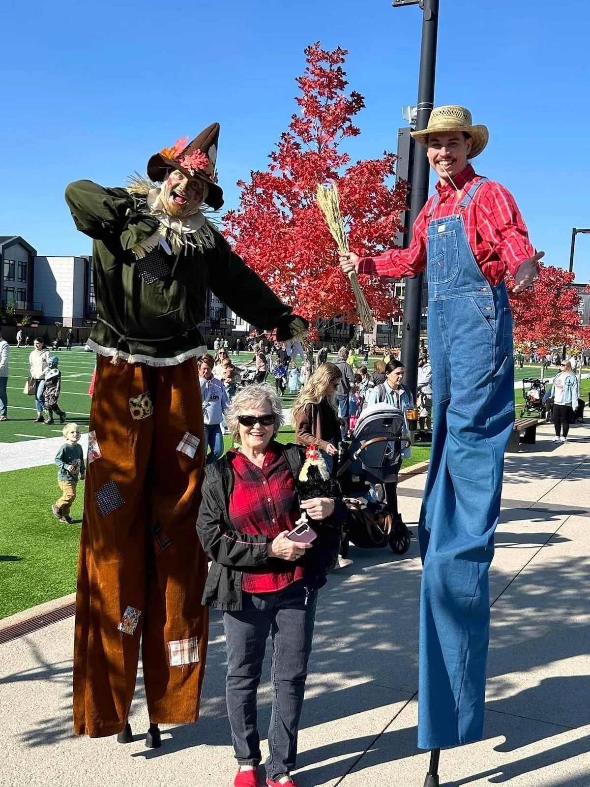 scarecrow and farmer pose with a guest