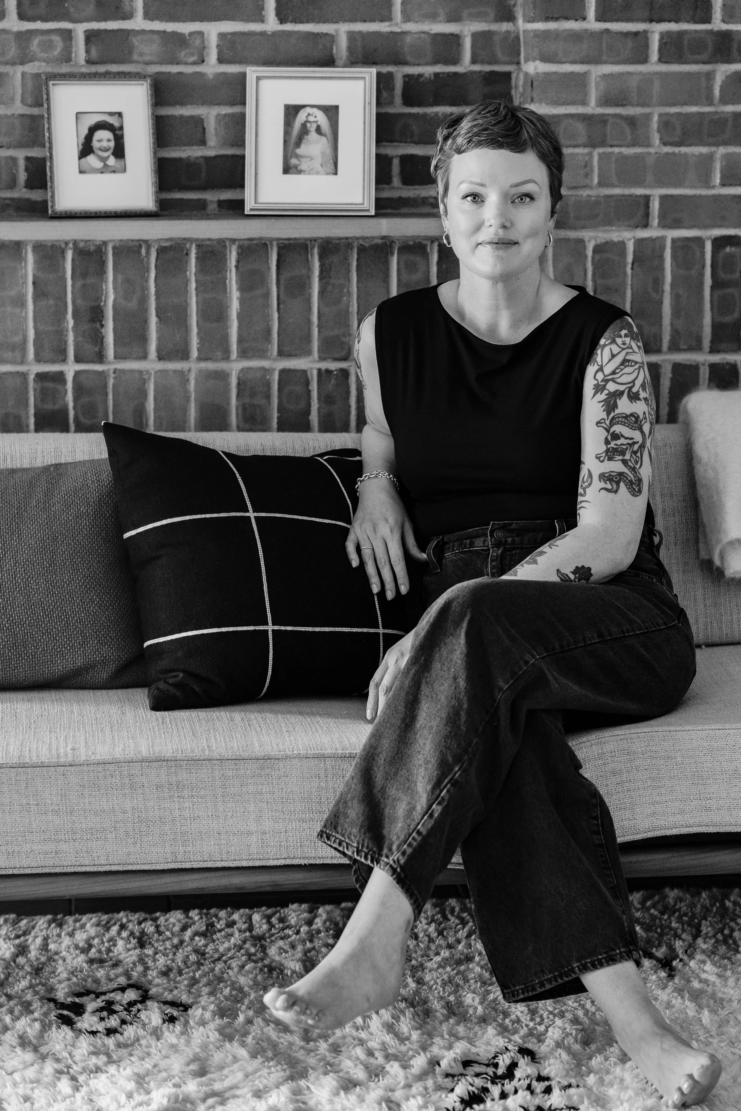 Author in her home seated in front of framed photos of her maternal grandmother and mother