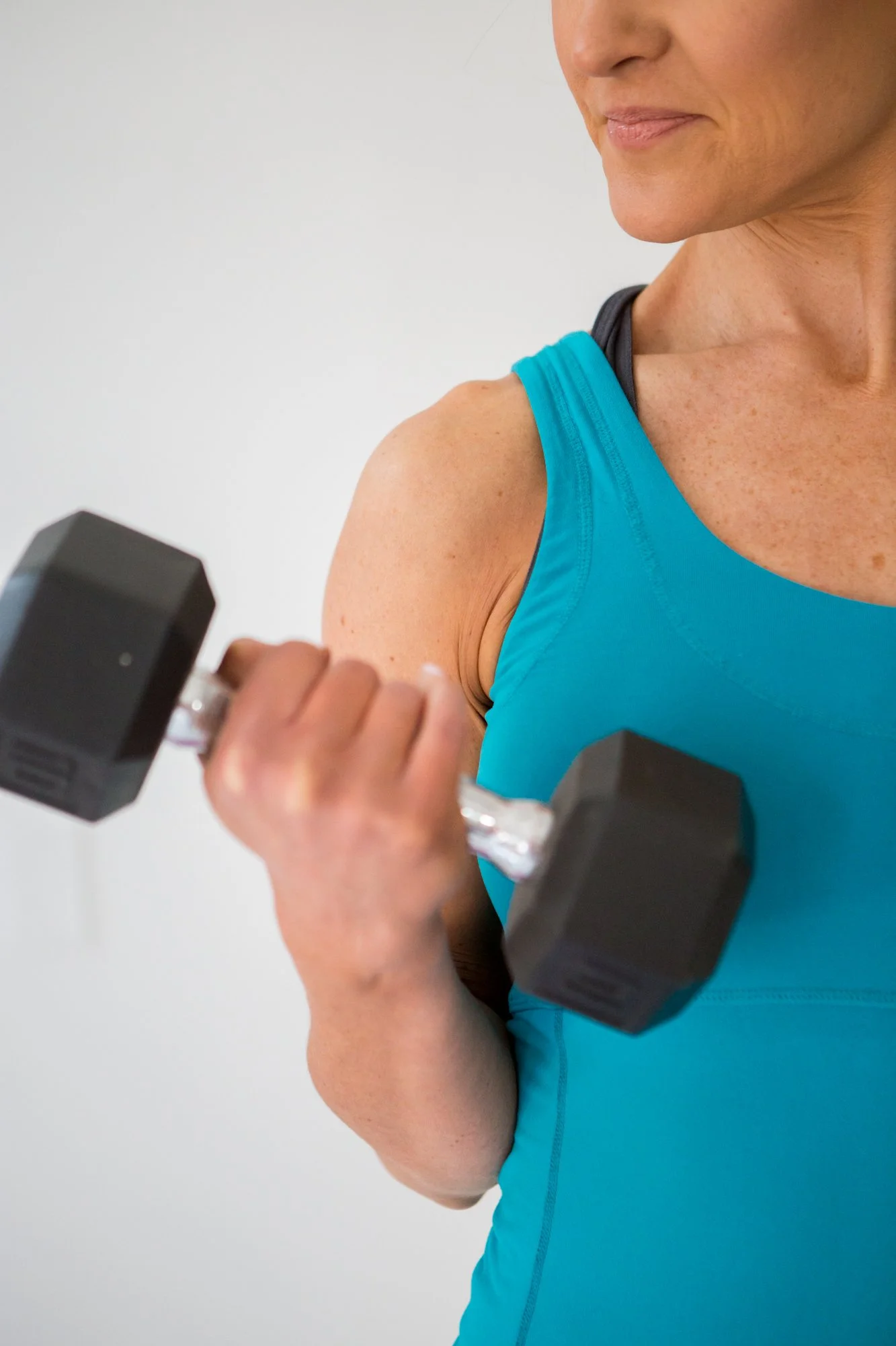 Midlife woman strength training with dumbbells to build muscle and support metabolism during perimenopause