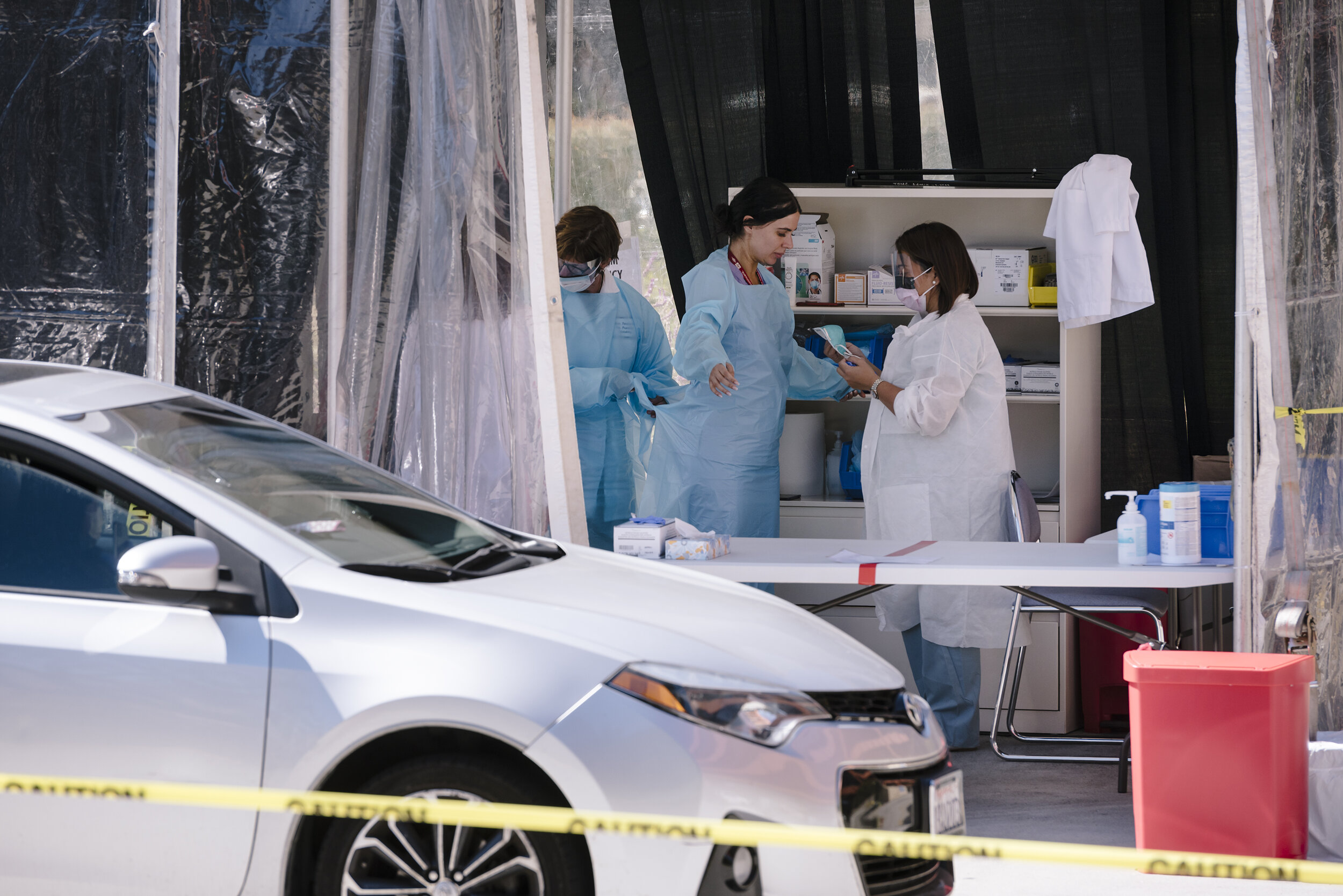  Kaiser clinicians put on protective gear as they prepare to test patients waiting in their cars at a drive-thru COVID-19 testing station on Kaiser Permanente's French Campus in San Francisco, California, US, on Wednesday, March 12, 2020.  For the Wa