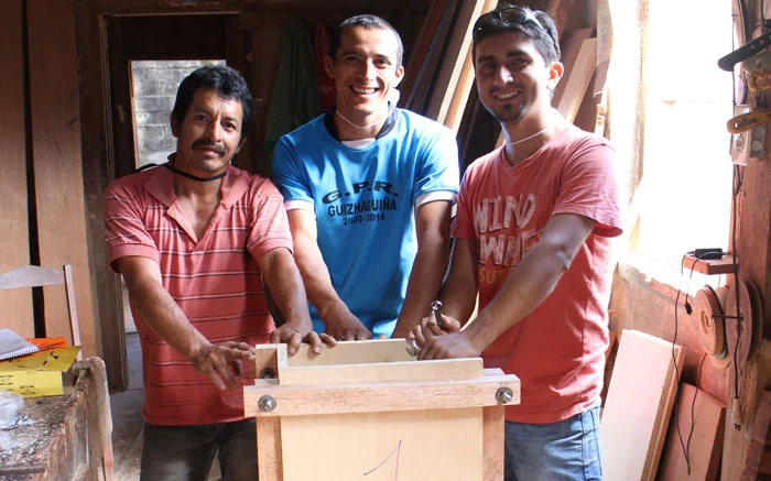 Jose, Fabian, and Johnathan stand proudly behind the Wood Mold they built together.