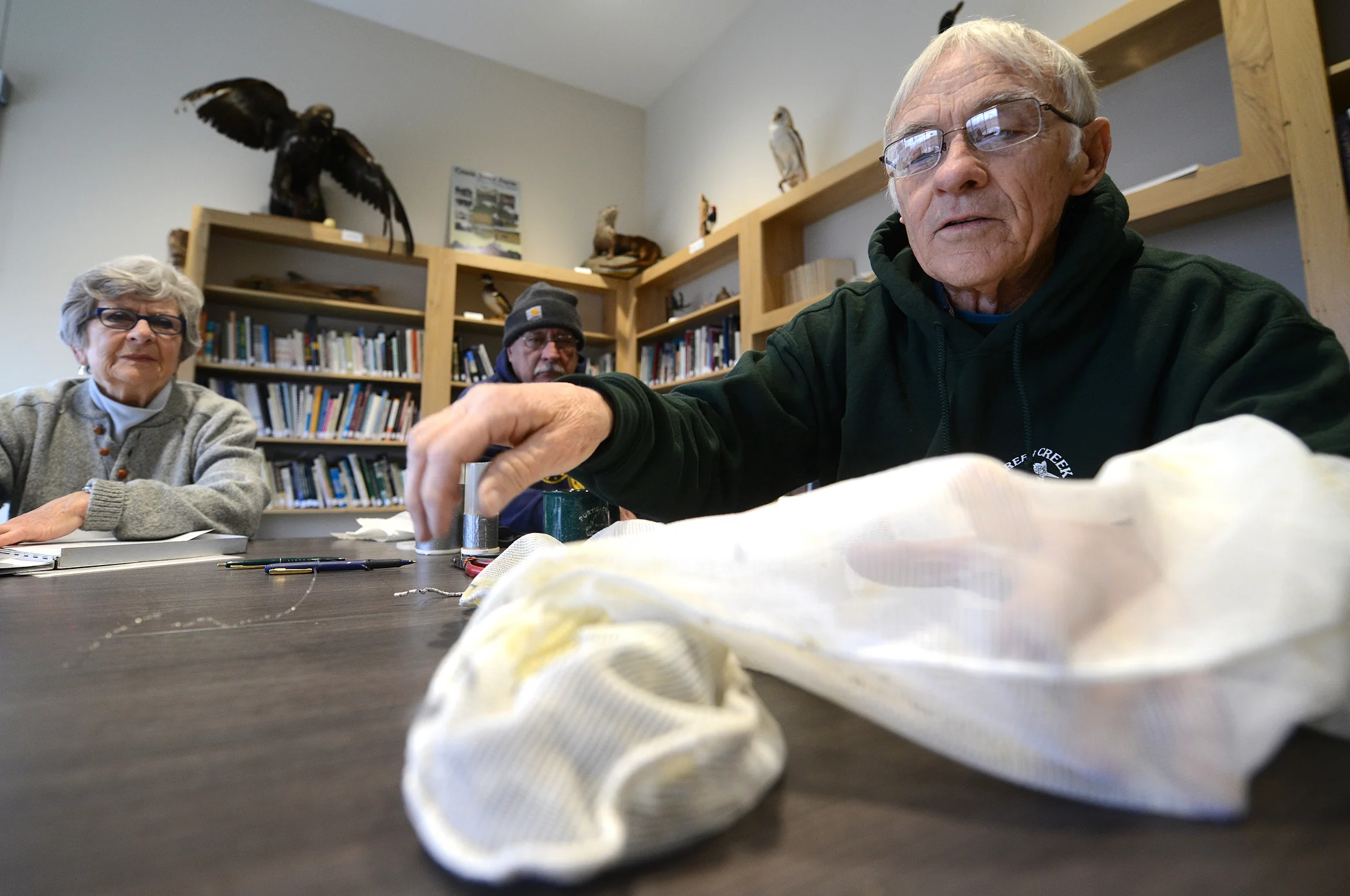  Volunteer bird bander Tom Kashmer reaches into a net bag to grab one of the birds to band in the library of Sandusky County Park District's Wilson Nature Center in Lindsey, Ohio on Thursday, January 25, 2018.  