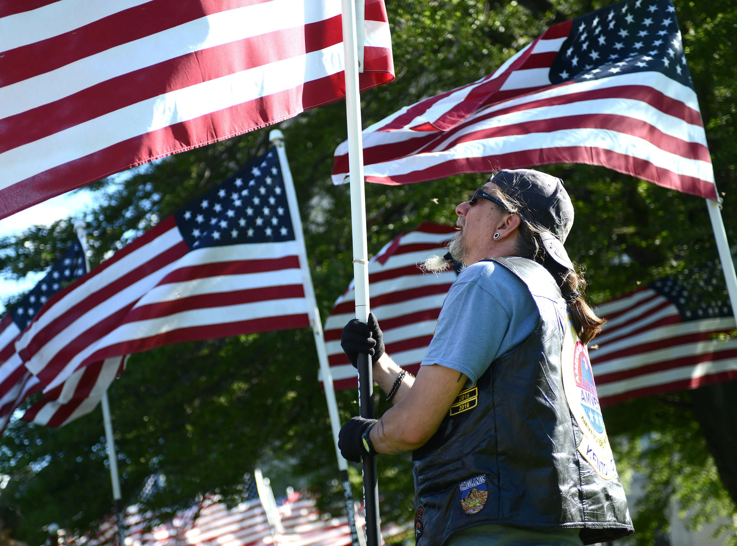  As hundreds of flags fly in the wind around him, Larry Lee, of Arlington, helps install the Ohio Flags of Honor at the Erie County Courthouse in downtown Sandusky on Wednesday, May 31, 2017. 